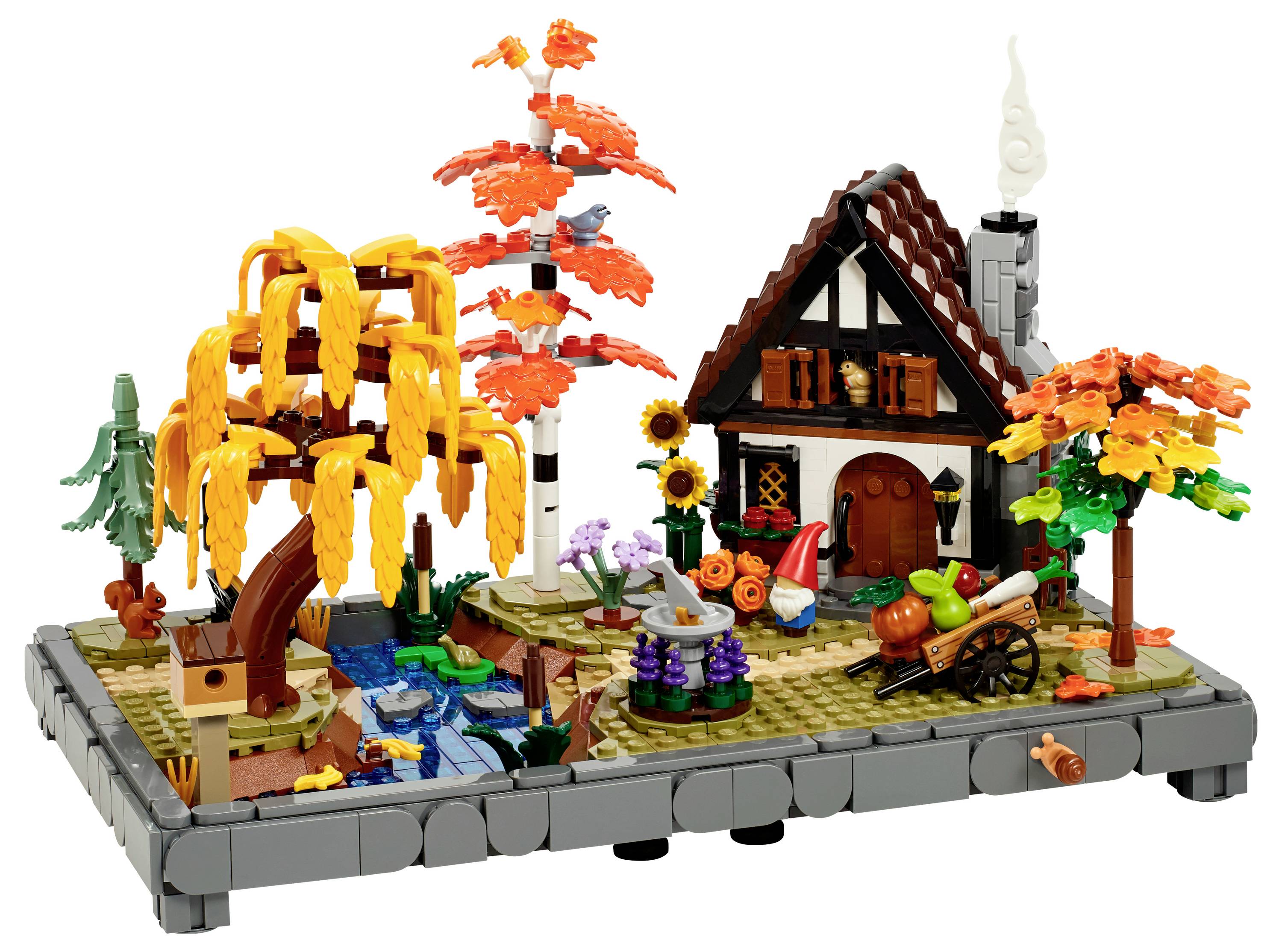 LEGO-Herbstszene mit einer Hütte, orangefarbenen und gelben Bäumen, einem kleinen Fluss, Pilzen und einem Karren voller Kürbisse, die eine gemütliche Atmosphäre schaffen.