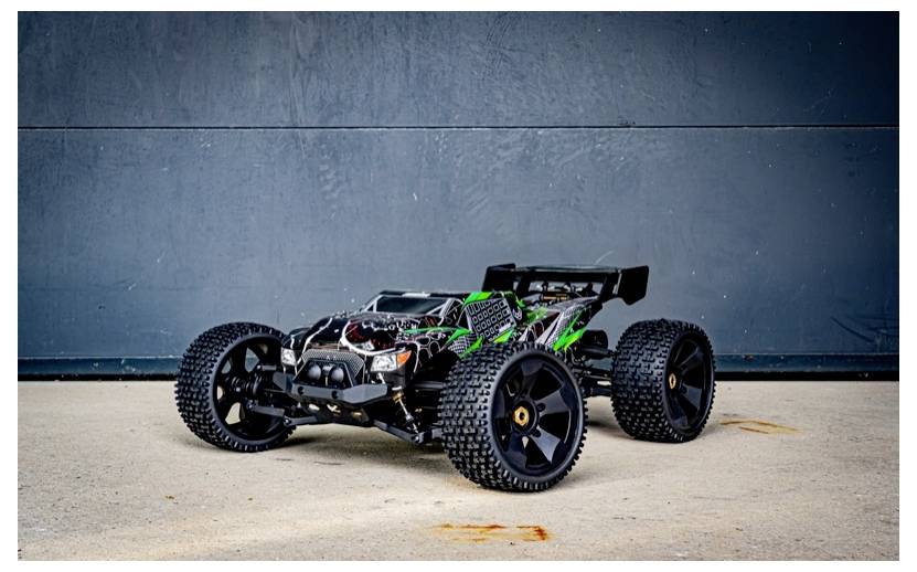Ein ferngesteuertes Auto mit grün-schwarzem Design, großen Rädern und freiliegenden mechanischen Bauteilen, das auf einer Betonoberfläche positioniert ist.