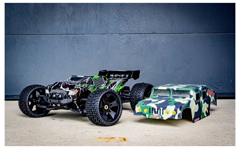 RC-Auto im Rennsetup neben einer Tarnfarben-Karosserie auf Beton.