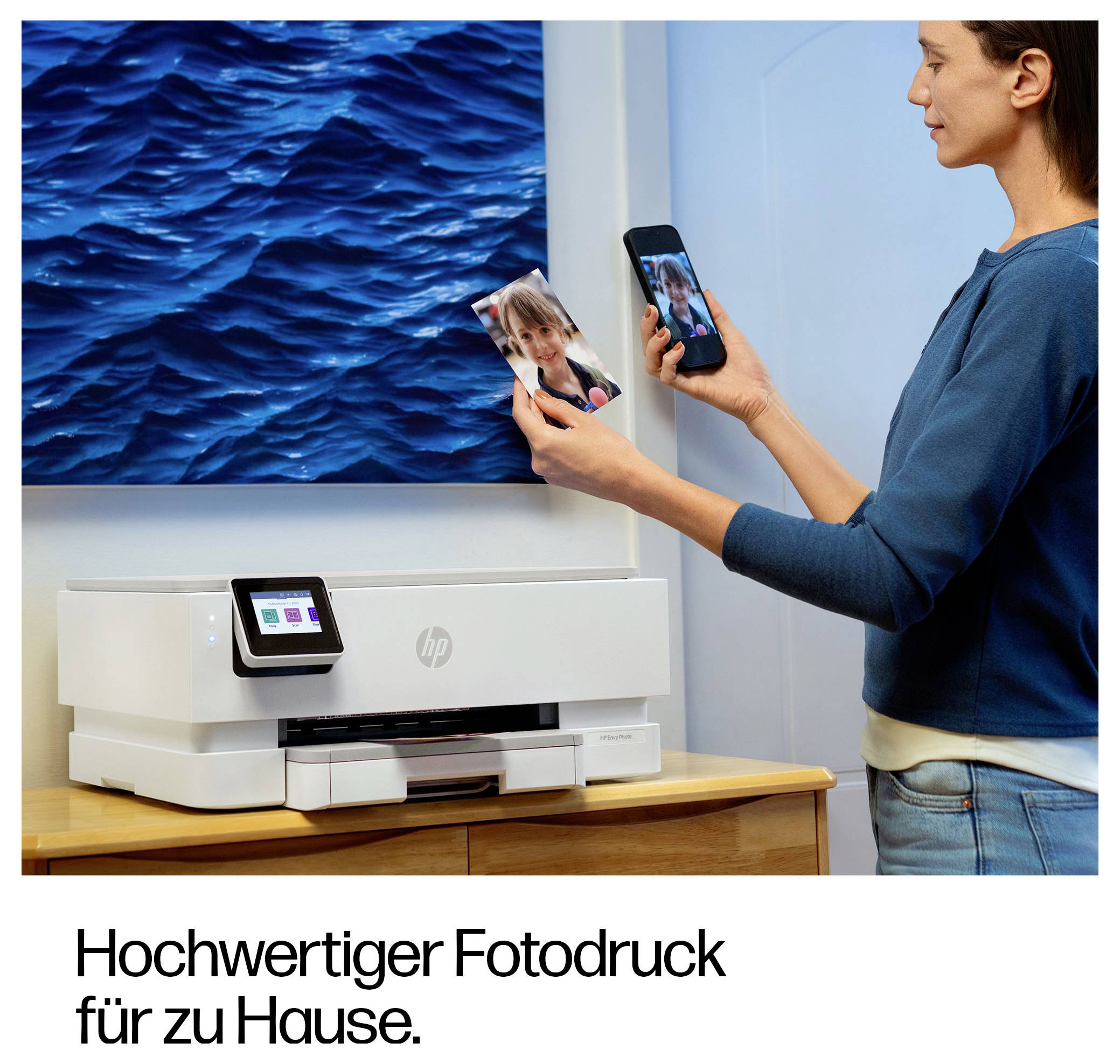 Eine Frau verwendet einen HP-Drucker, um ein Foto von ihrem Smartphone zu Hause auszudrucken; der Anzeigentext lautet „Hochwertiger Fotodruck für zu Hause."