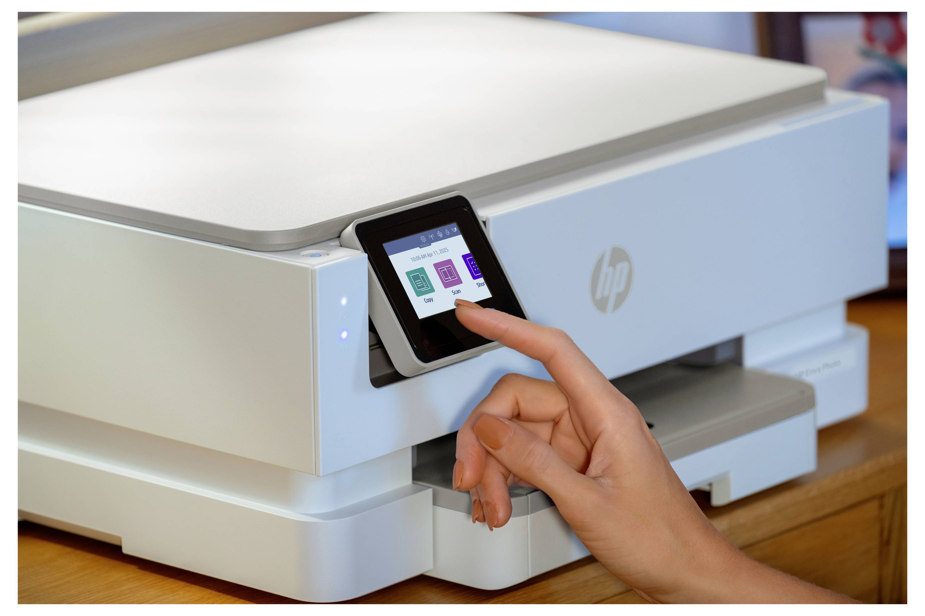 Eine Person interagiert mit dem Touchscreen-Interface eines modernen Druckers und wählt Optionen aus einem Menü aus, an einem Holzschreibtisch.