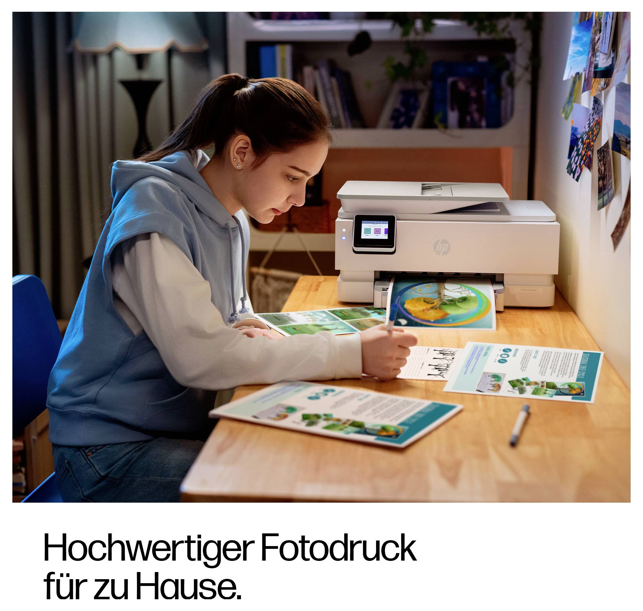 Ein Mädchen im Teenageralter studiert gedruckte Fotoblätter an einem Schreibtisch neben einem Heimdrucker; der Anzeigentext lautet „Hochwertiger Fotodruck für zu Hause."