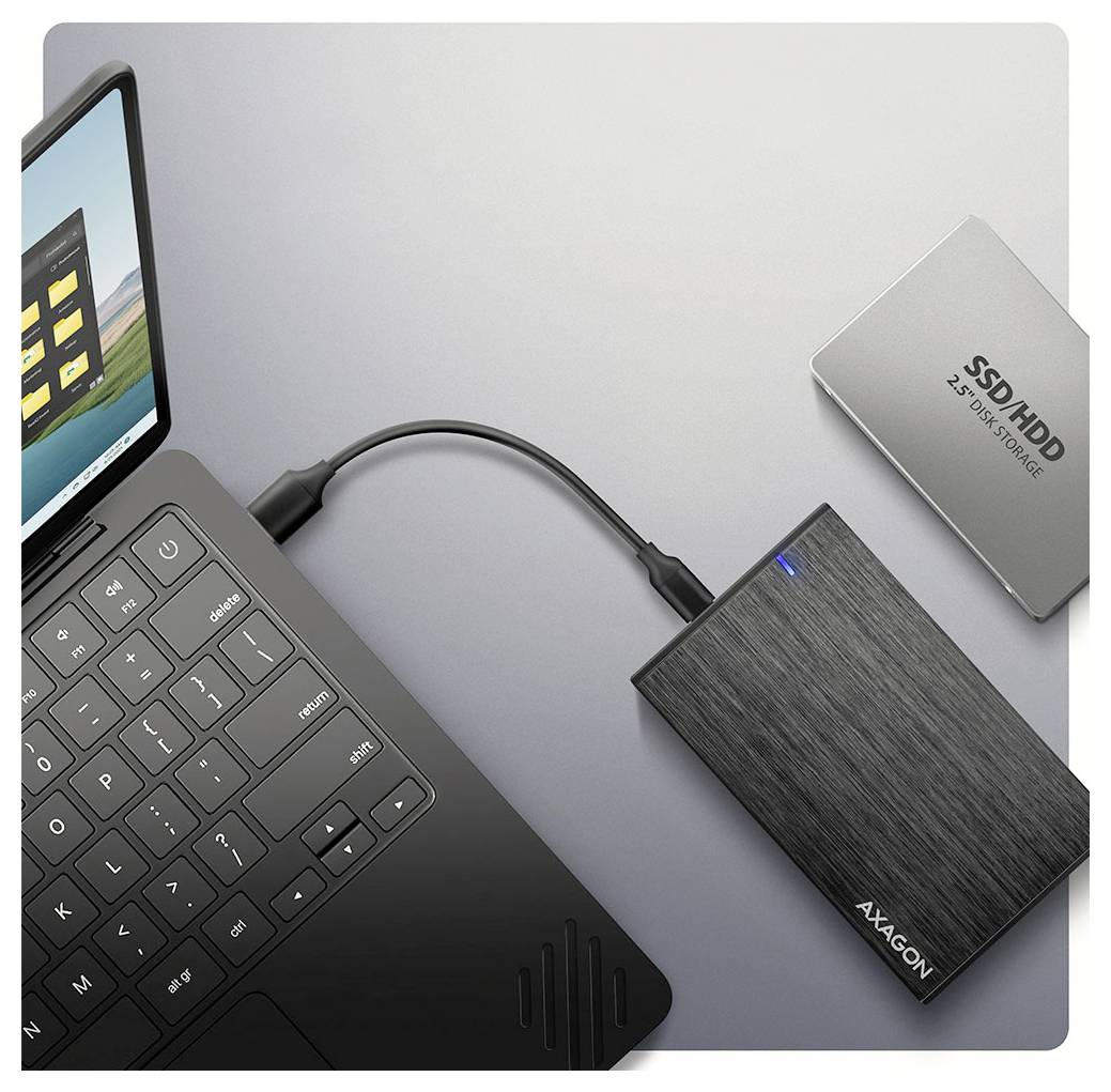 Ein Laptop ist über ein Kabel mit einer schwarzen externen Festplatte verbunden. Daneben befindet sich eine silberne interne SSD, gekennzeichnet mit 'SSD/HDD 2.5