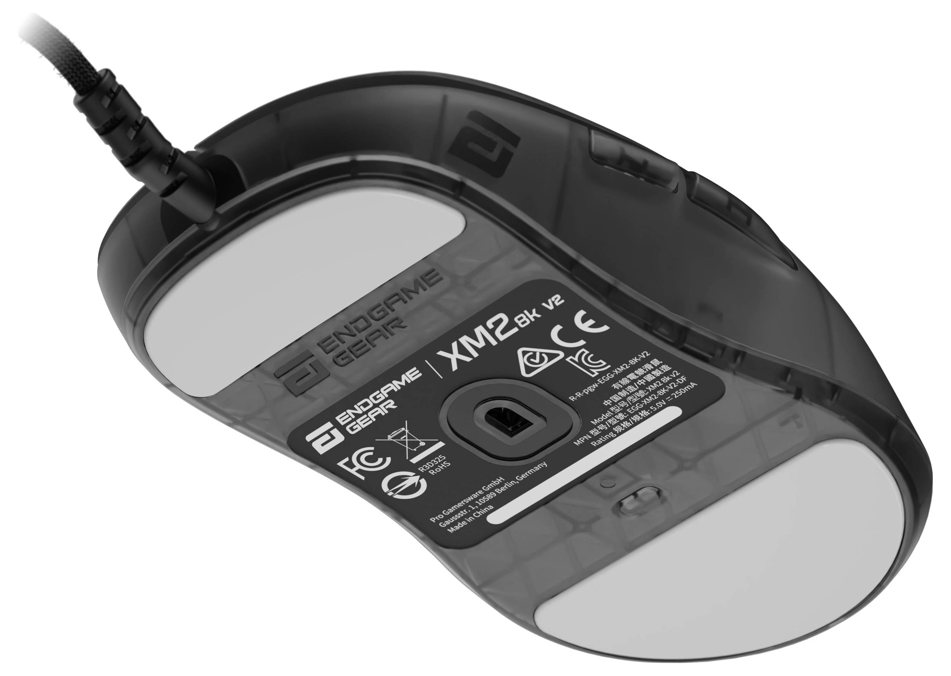 Eine schwarze Endgame Gear XM1r Maus mit weißen Gleitflächen und Zertifizierungsmarkierungen, von der Unterseite betrachtet.