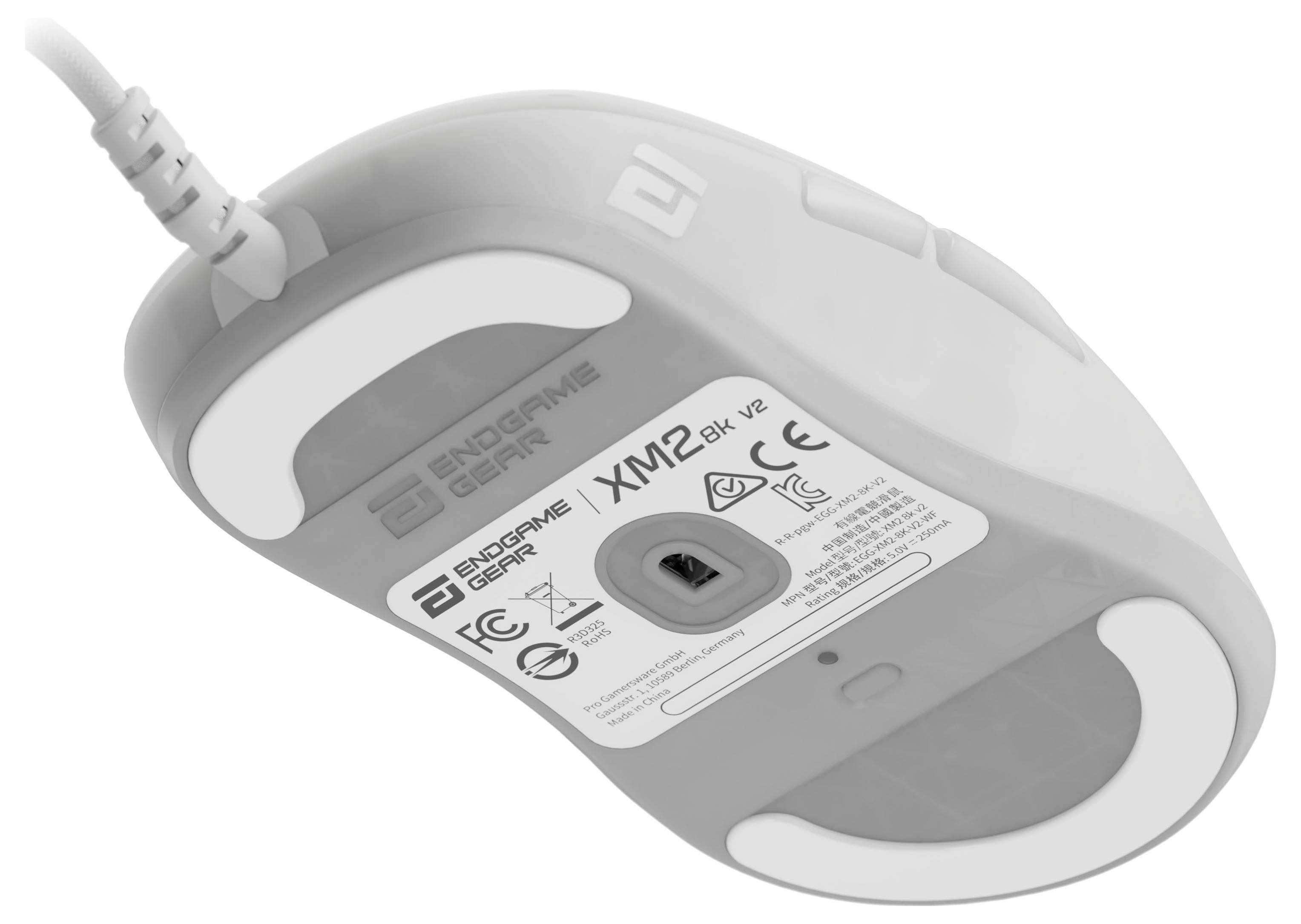 Eine weiße Computermaus, die ihre Unterseite zeigt, mit einem grauen Etikett mit technischen Spezifikationen und Sicherheitssymbolen.
