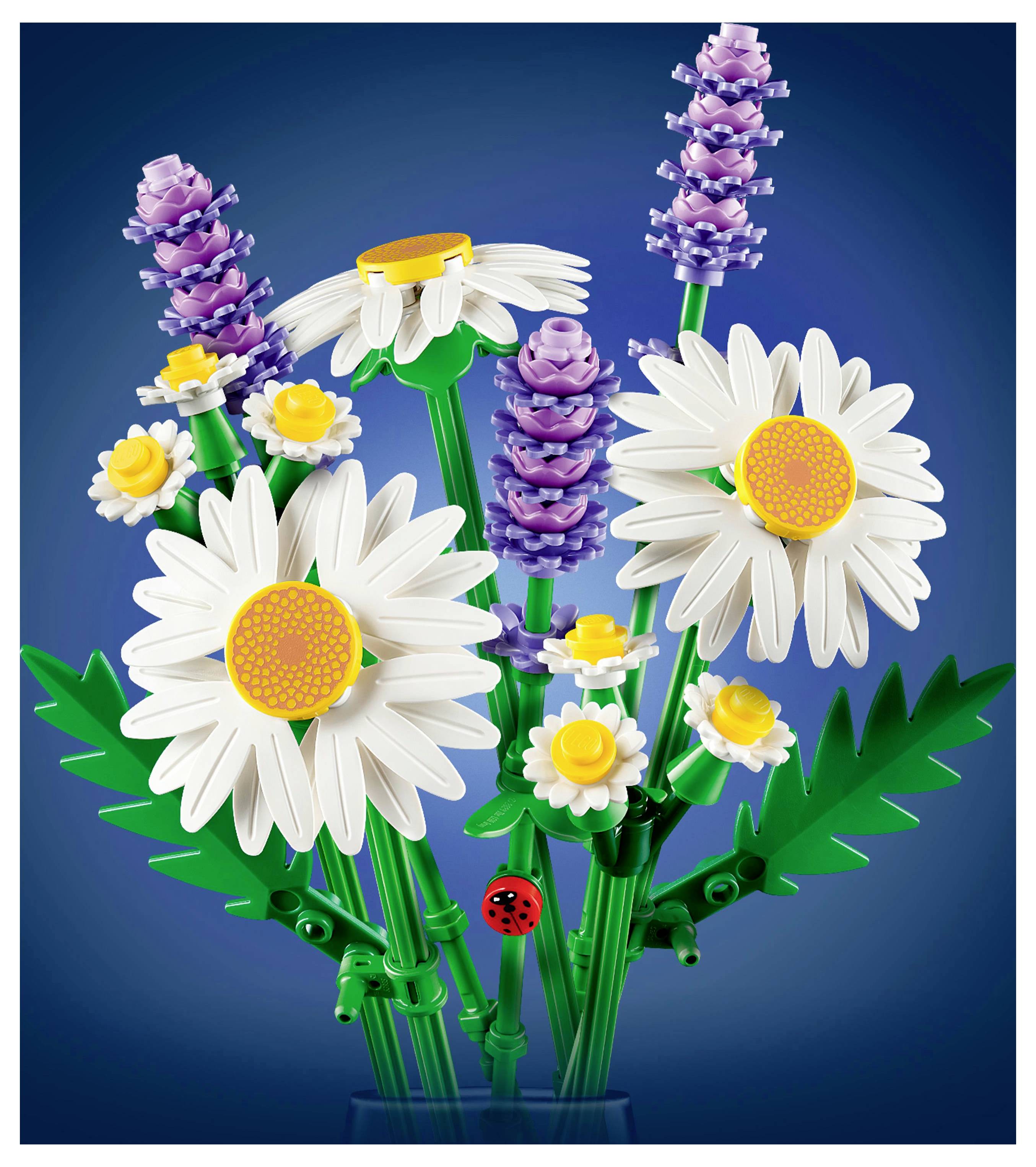 Ein bunter Blumenstrauß aus Spielbausteinen, bestehend aus weißen Gänseblümchen, kleinen gelben Blüten, violetten Blumen und grünen Blättern.