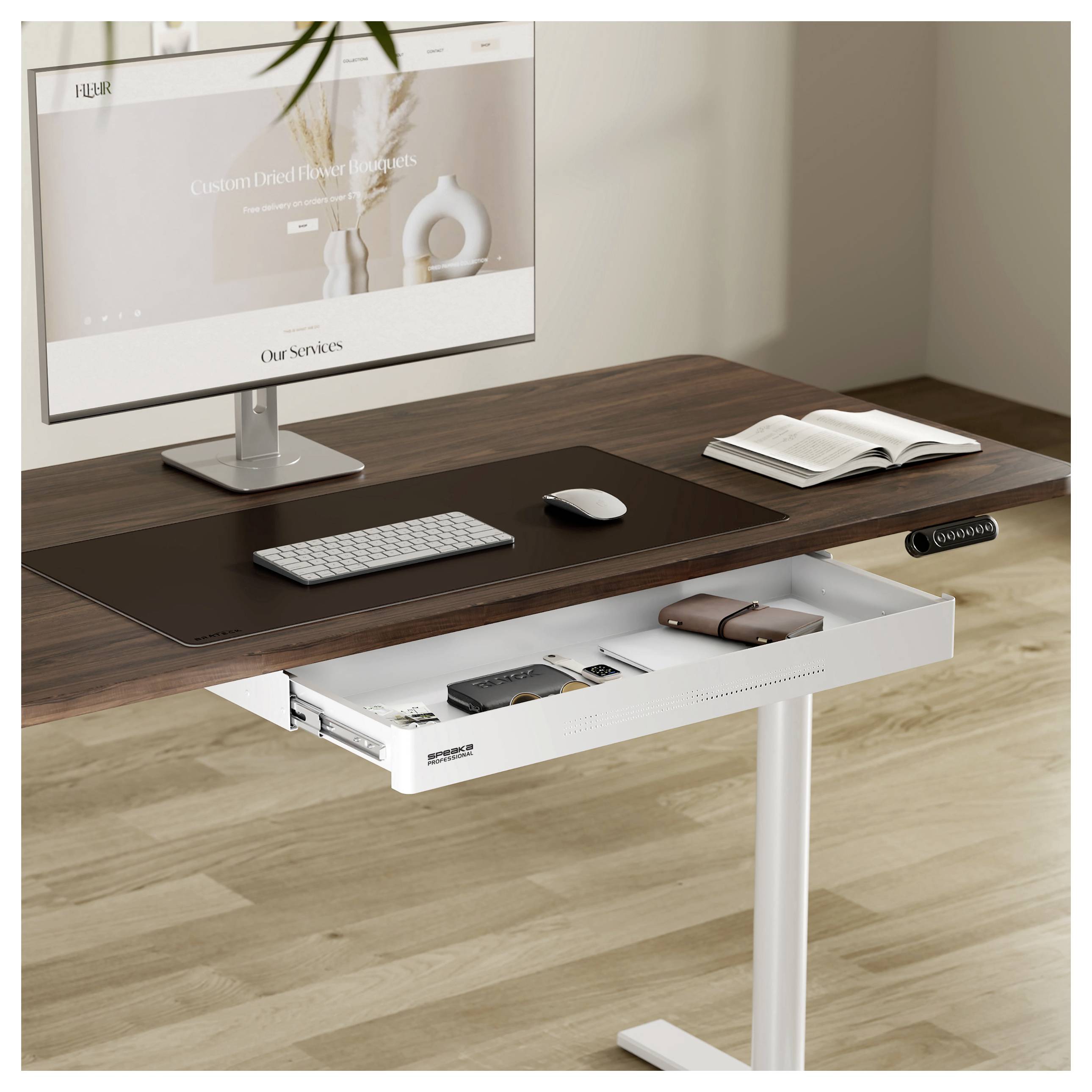 Ein moderner Arbeitsplatz mit einem Holzschreibtisch, auf dem ein Computerbildschirm und eine Tastatur stehen, und einer offenen Schublade mit einem Notizbuch und technischem Zubehör.