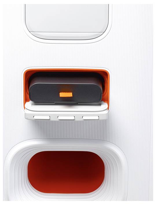 Ein weißes rechteckiges Gerät mit einem orange-schwarzen Fach, das Tasten und abgerundete Öffnungen aufweist, vermutlich technologiebezogen.