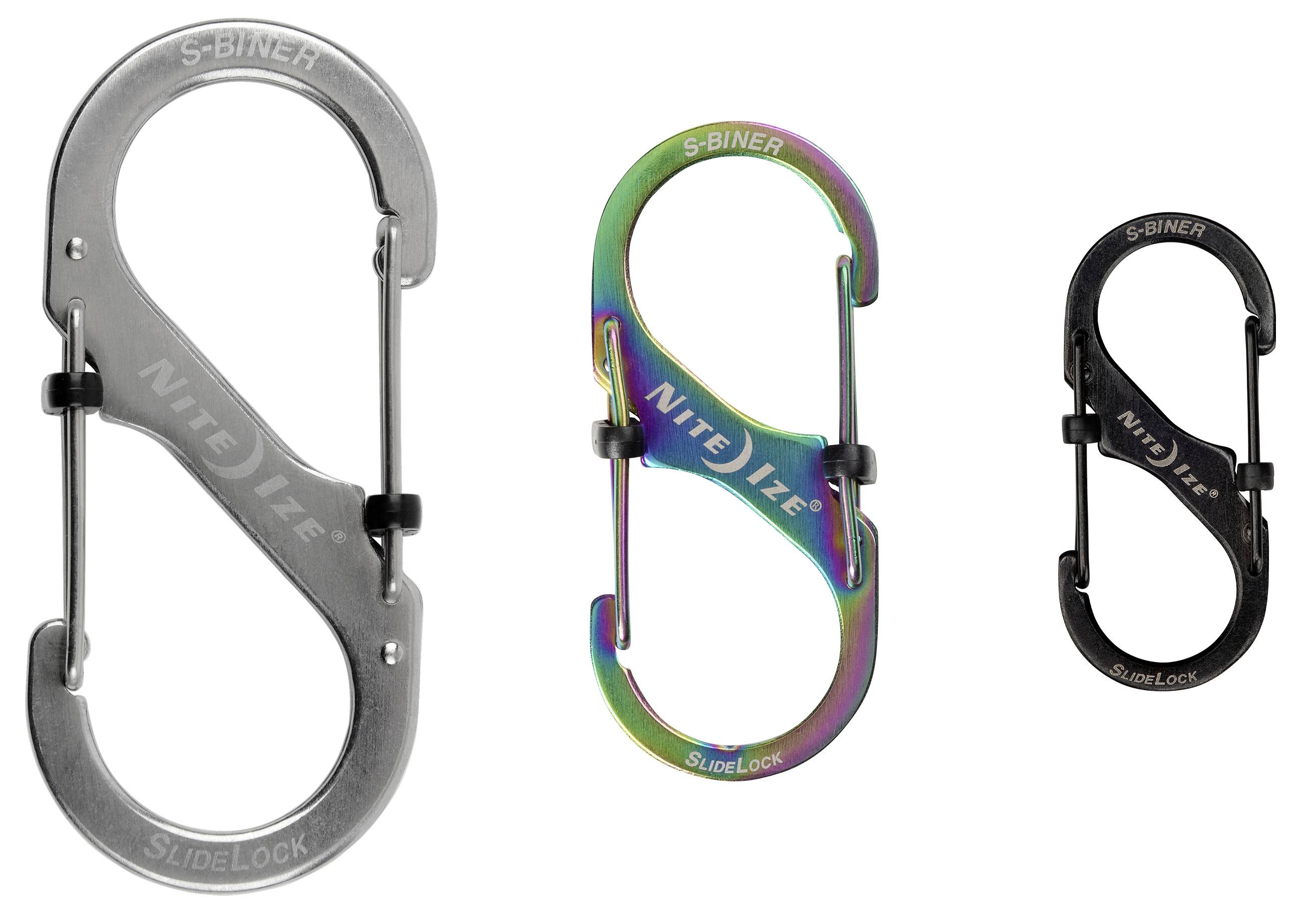 Drei S-Biner-Karabiner in verschiedenen Größen und Farben werden präsentiert: silber, regenbogenfarben und schwarz, jeweils mit dem Etikett 'Nite Ize SlideLock' versehen.