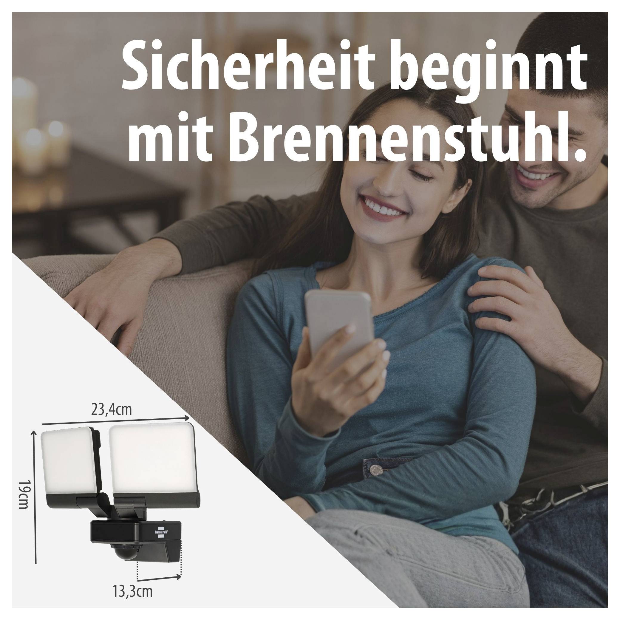 Werbebild für Brennenstuhl: lächelndes Paar auf dem Sofa, unten links ein Sicherheitsstrahler mit Maßangaben 23,4 cm, 19 cm und 13,3 cm.