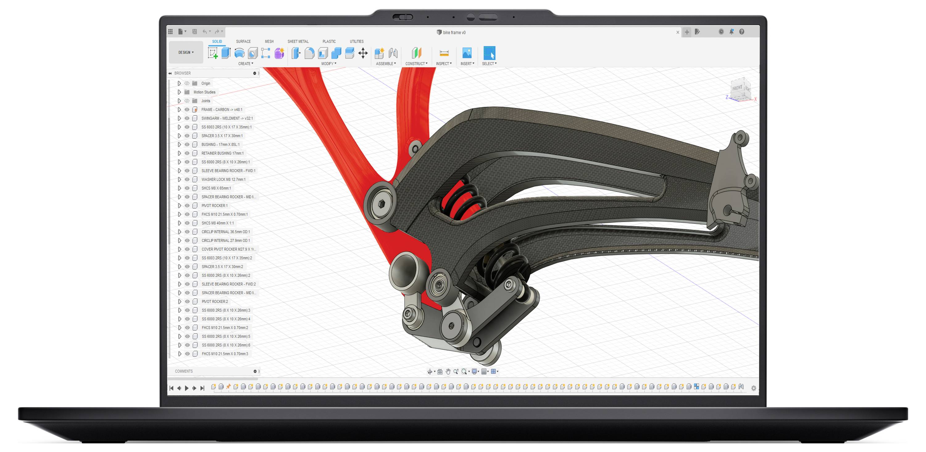 Ein Laptopbildschirm zeigt eine 3D-CAD-Software-Oberfläche mit einem detaillierten Modell eines mechanischen Federsystems, das rote und schwarze Komponenten aufweist.