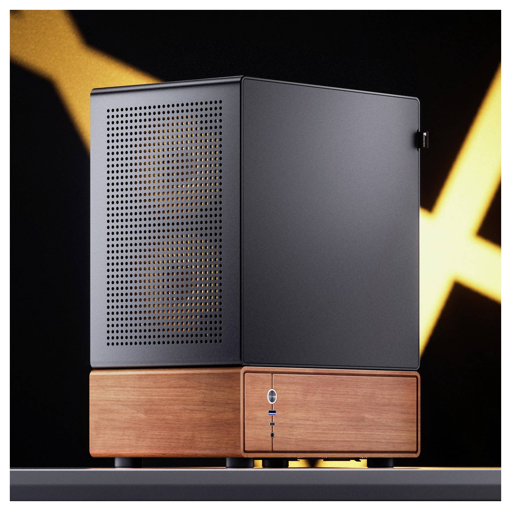 Ein kleiner, moderner Desktop-Computer mit durchlochter schwarzer Oberseite steht auf einer Holzunterlage, vor einem dunkel beleuchteten Hintergrund.