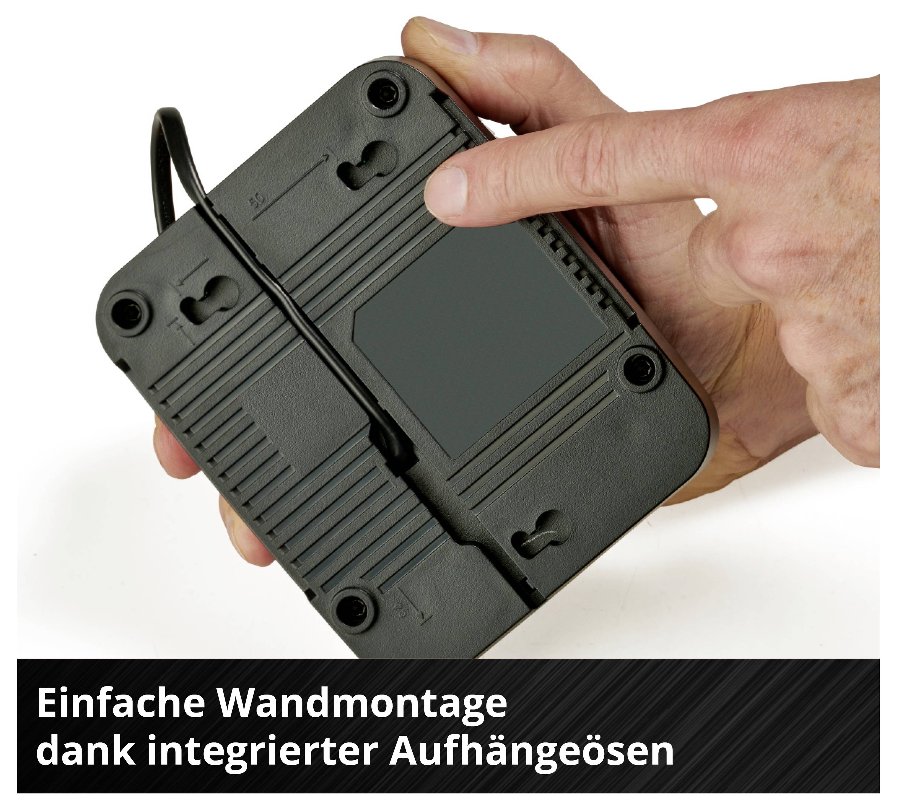 Schwarzes Gerät von unten mit Kabel, zwei integrierten Aufhängeösen und einer Hand, die darauf zeigt. Text: 'Einfache Wandmontage dank integrierter Aufhängeösen'.