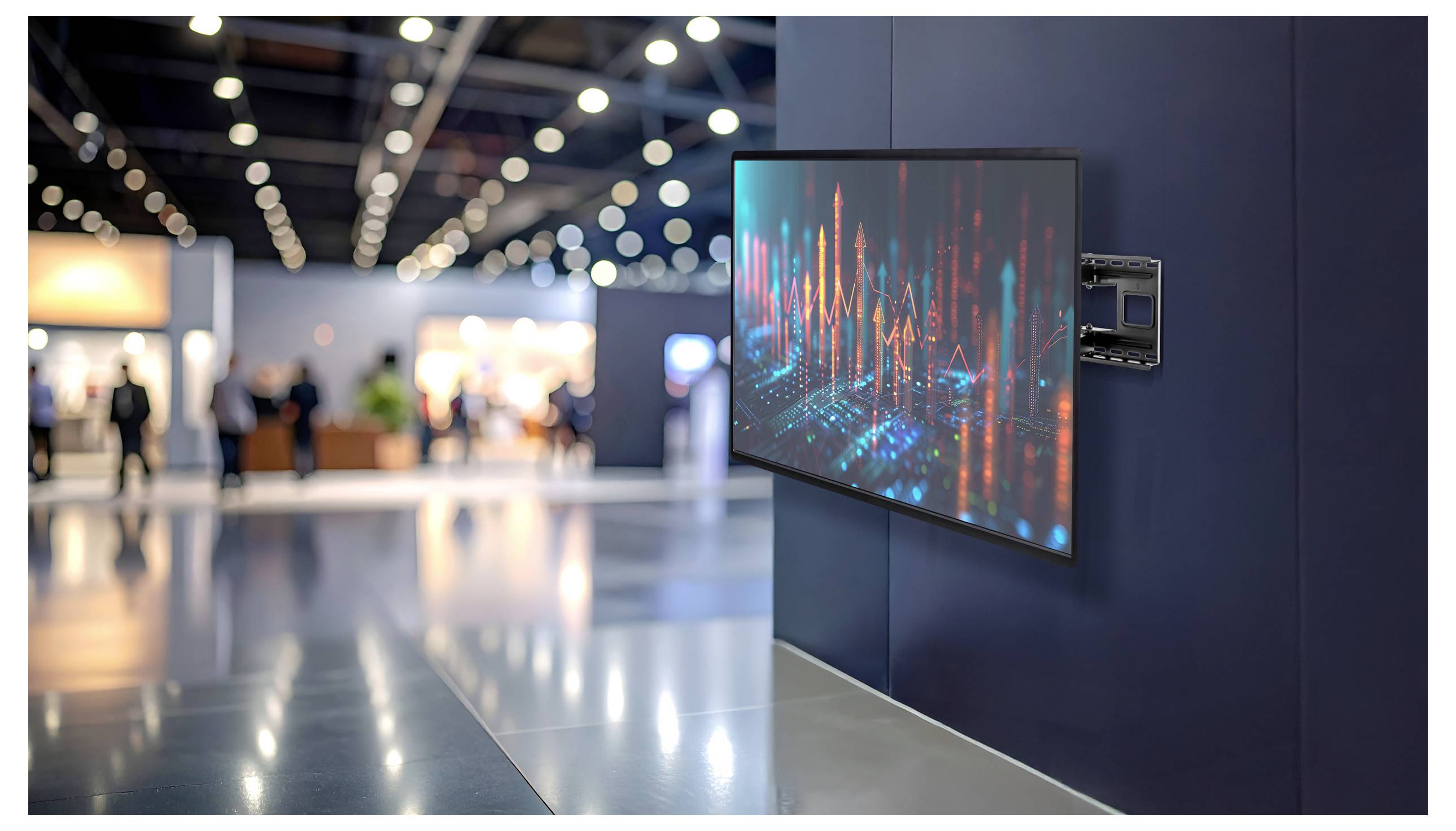 Eine große digitale Anzeige mit farbenfrohen Graphen ist an einer Wand in einer modernen, geräumigen Ausstellungshalle mit unscharfen Besuchern im Hintergrund angebracht.