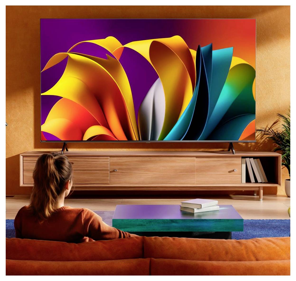 Eine Person betrachtet einen großen Fernseher, der abstrakte Kunst in lebhaften, bunten Farben zeigt, in einem modernen Wohnzimmer mit orangefarbenen Wänden und einem Holz-Fernsehschrank.