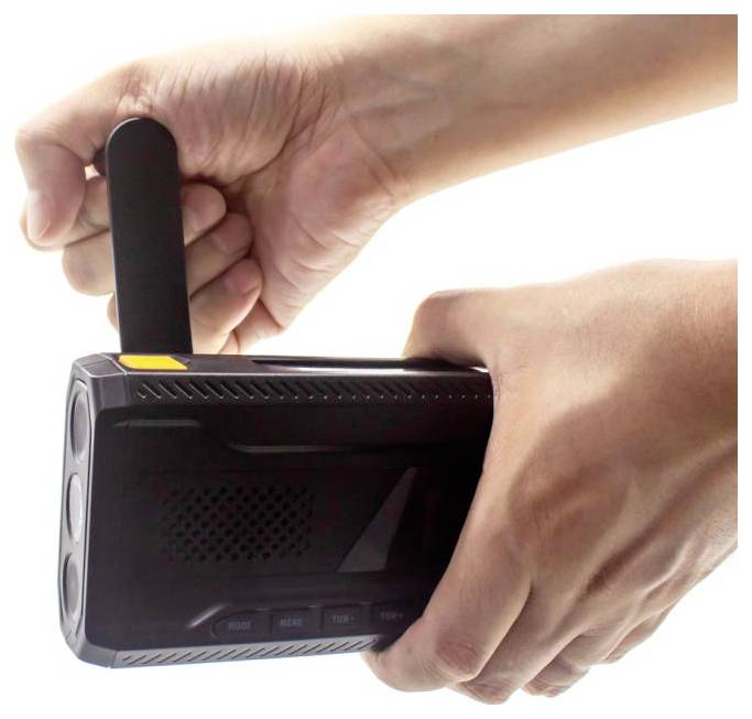 Eine Hand hält ein tragbares Radio, während eine andere Hand dessen Kurbel dreht.