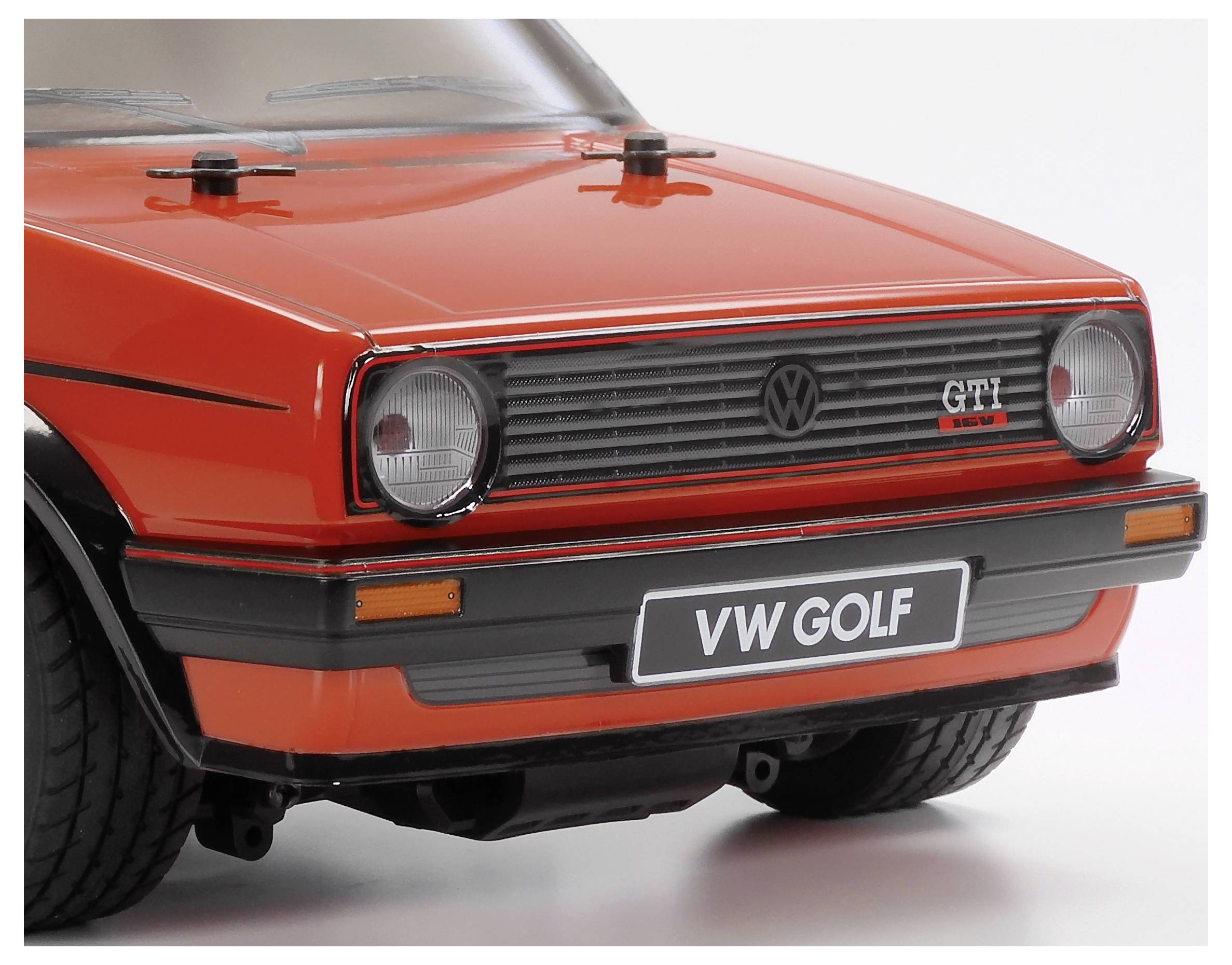Frontansicht eines roten Vintage VW Golf GTI Modellautos, mit charakteristischen runden Scheinwerfern und einem klassischen Kühlergrill, auf weißem Hintergrund.