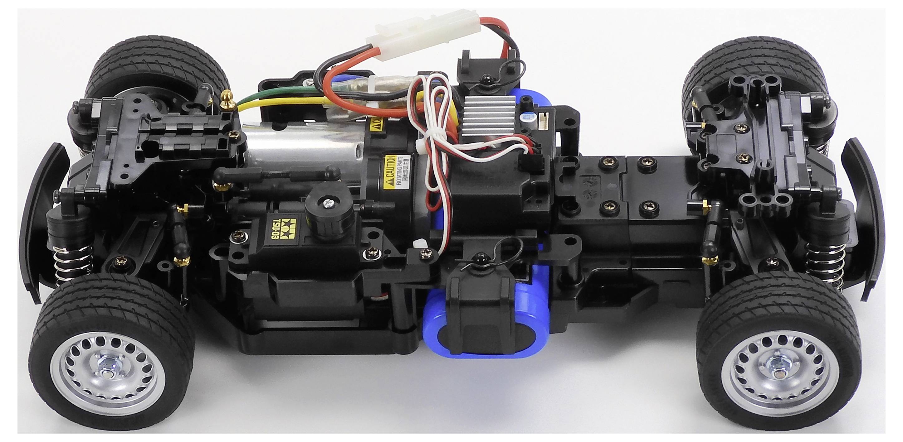 Draufsicht eines teilweise montierten RC-Auto-Chassis mit Verkabelung, Motor, Federung und Rädern.