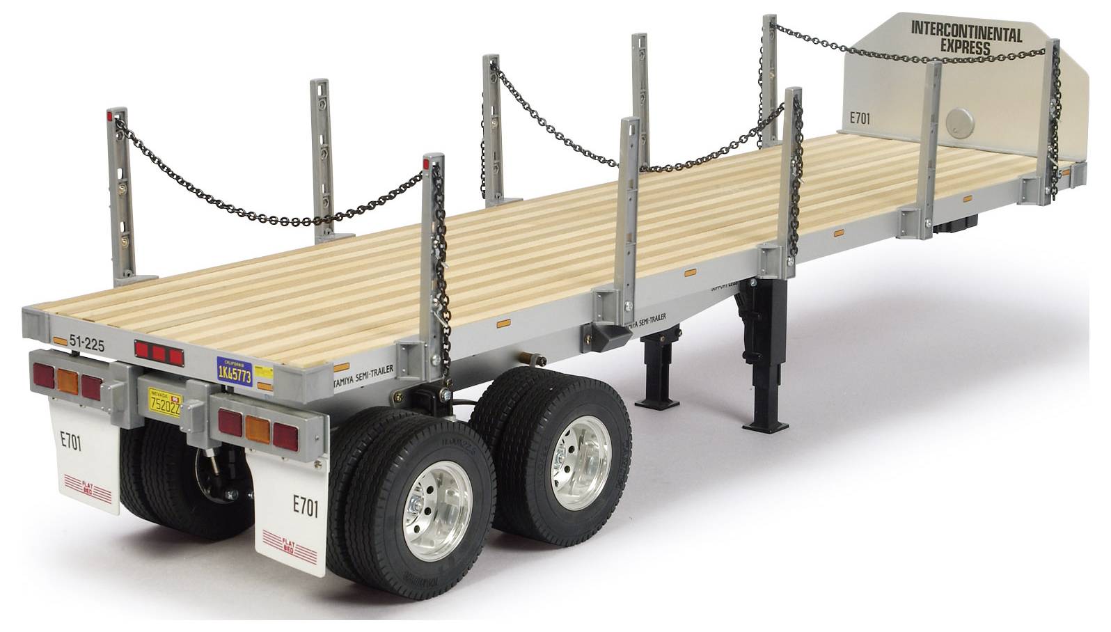 Ein Modell eines Pritschenanhängers mit Ketten und Beschriftungen, konzipiert für den Transport schwerer Güter.