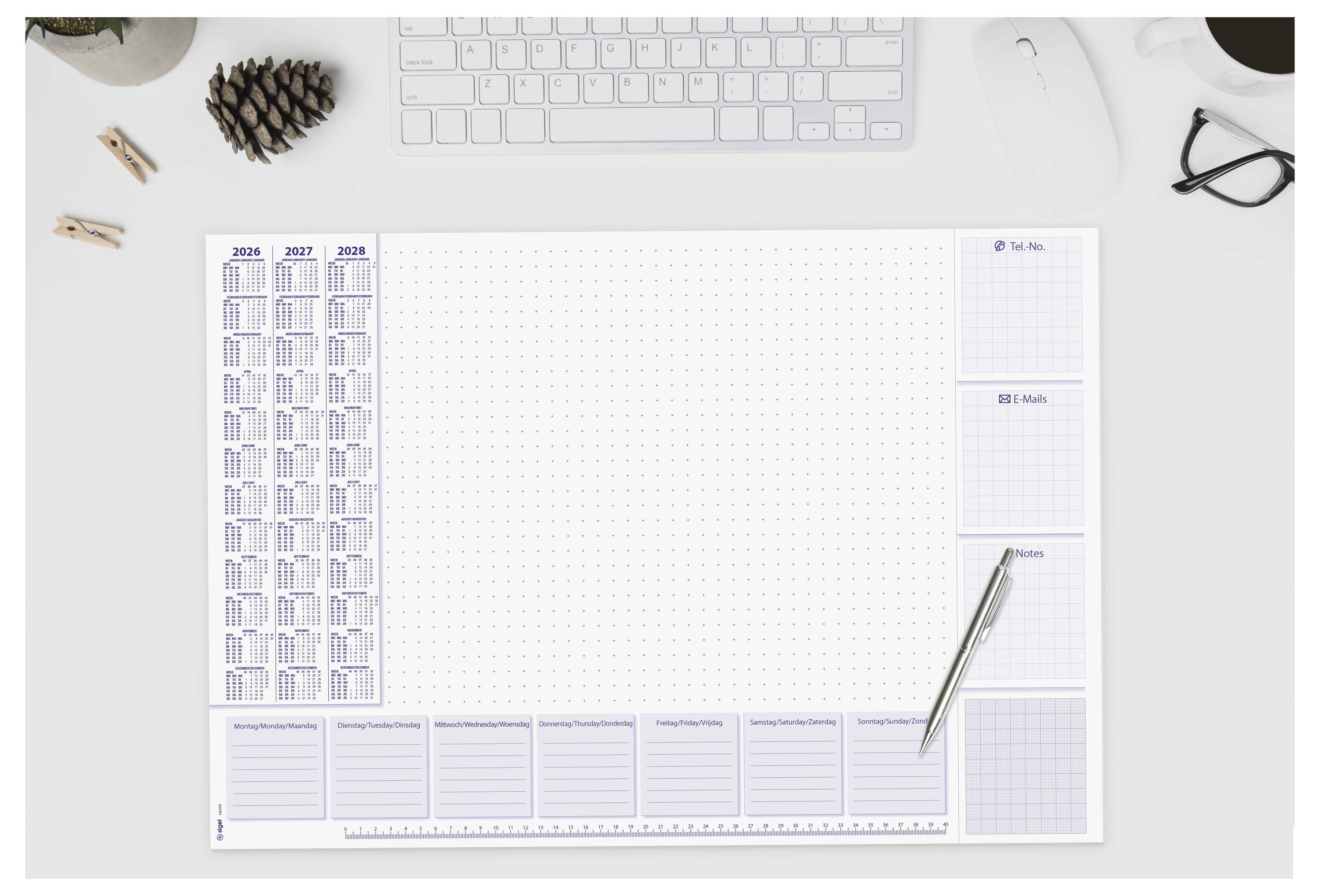 Schreibtischorganizer mit gepunkteter Notizsektion, Jahreskalender für 2021-2023, To-Do-Liste, Zielen und anderen Aufgabenbereichen, Tastatur und Stift in der Nähe.