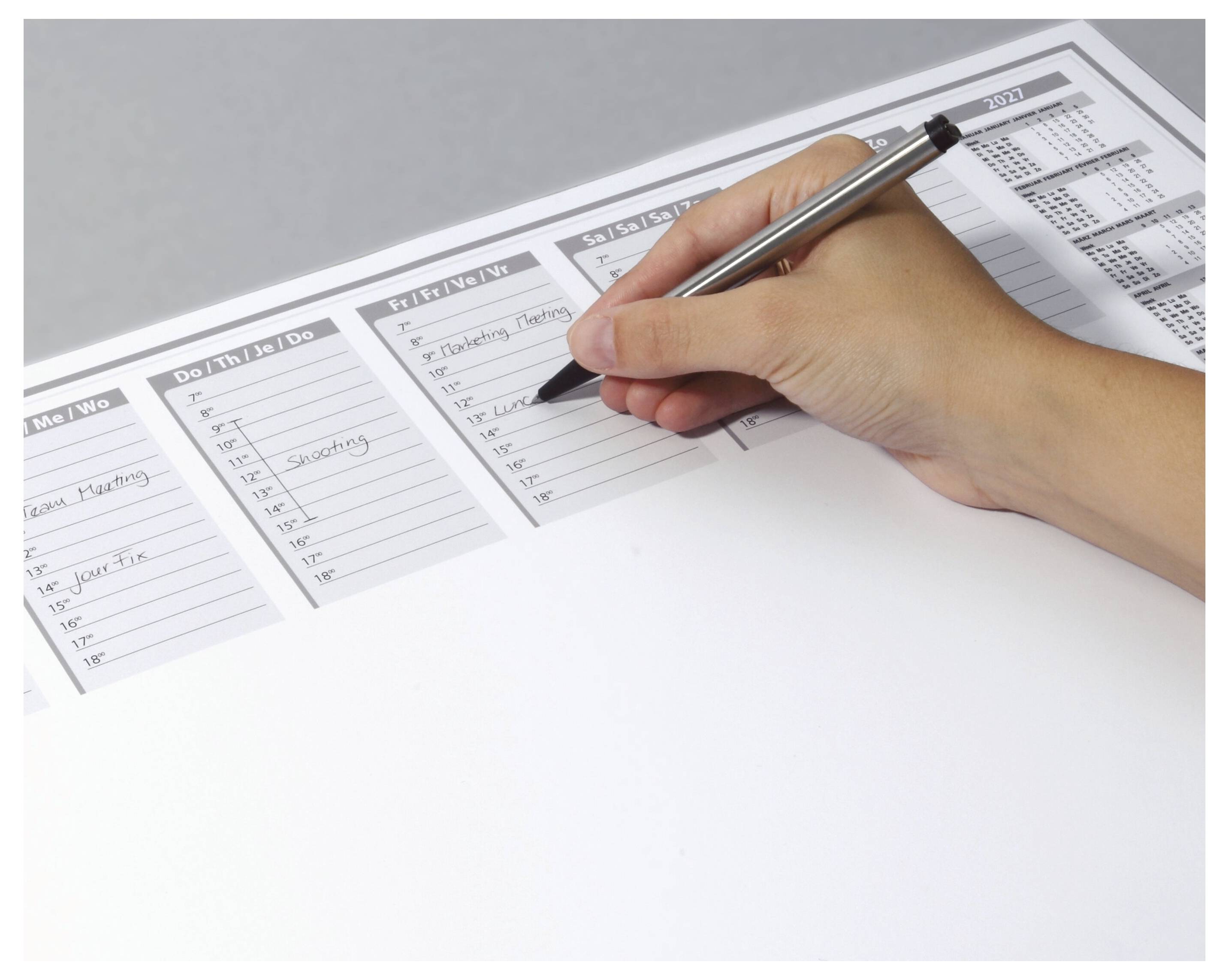 Eine Hand, die in einen Planer mit Abschnitten für Aufgaben von Montag bis Sonntag schreibt. Der Planer enthält einen kleinen Kalender.