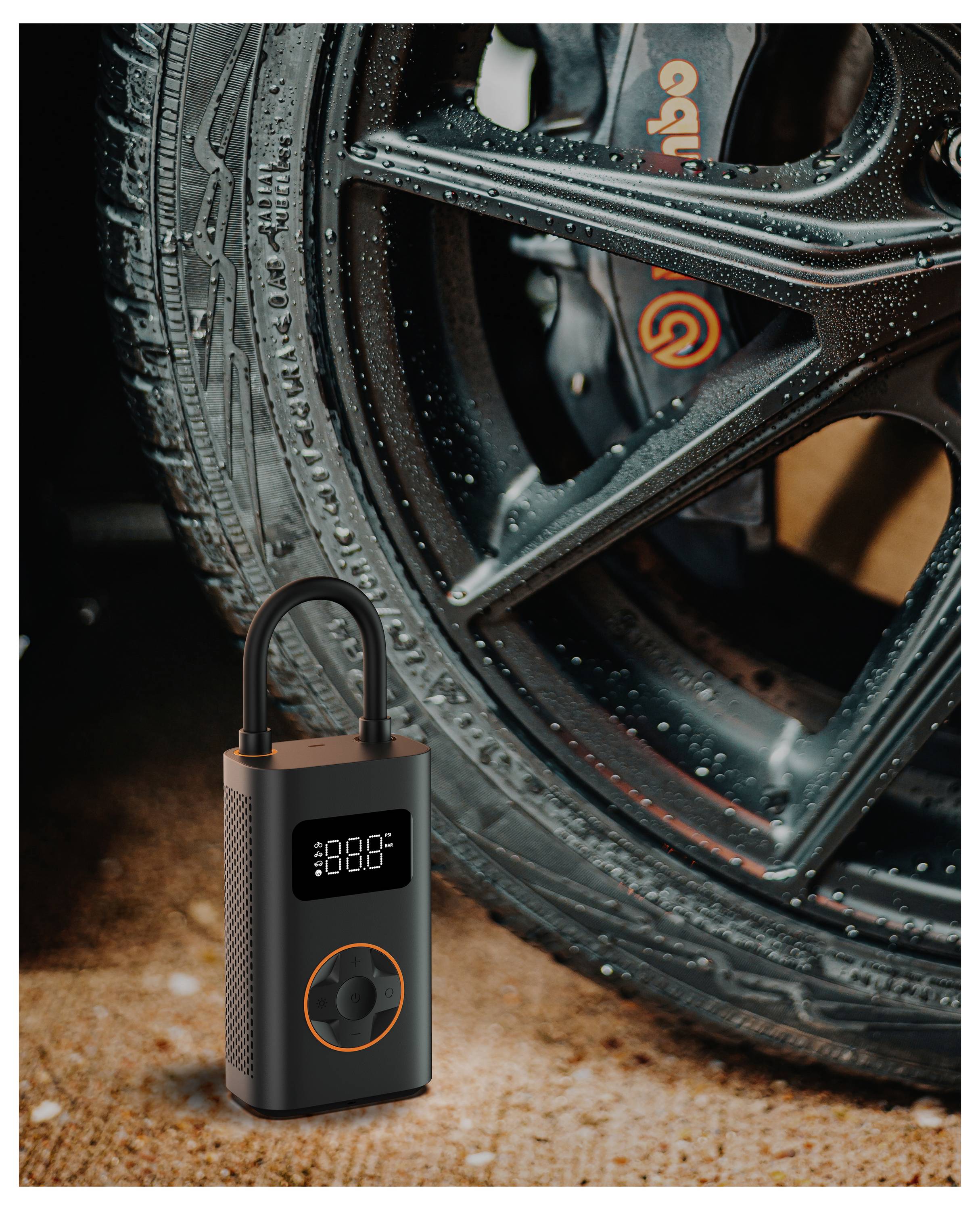 Ein tragbarer Reifenaufpumper mit einer beleuchteten digitalen Anzeige, die '888.8' zeigt, liegt neben einem Autoreifen auf einer strukturierten Oberfläche.