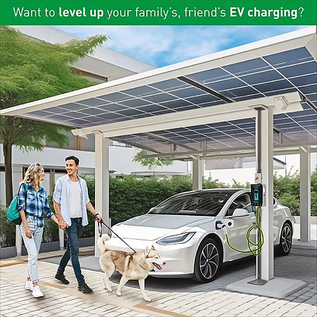 Ein Paar und ihr Hund gehen unter einem Solarpaneldach mit einer Ladestation für Elektrofahrzeuge. Das Schild liest: „Möchten Sie Ihr EV-Laden auf die nächste Stufe heben?