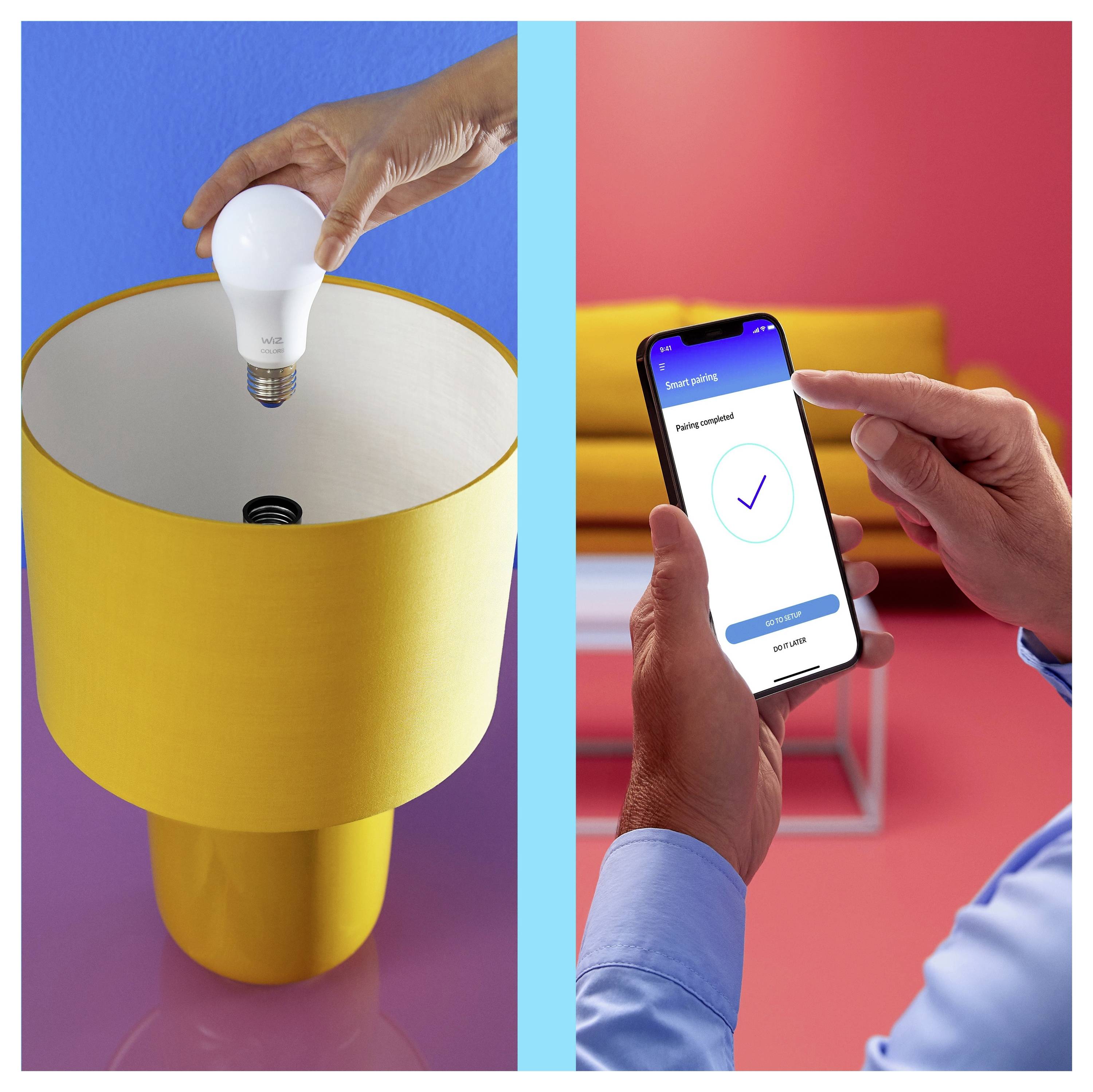 Eine Person installiert eine Smart-Glühbirne in einer gelben Lampe, während eine andere eine Smartphone-App prüft, auf der 