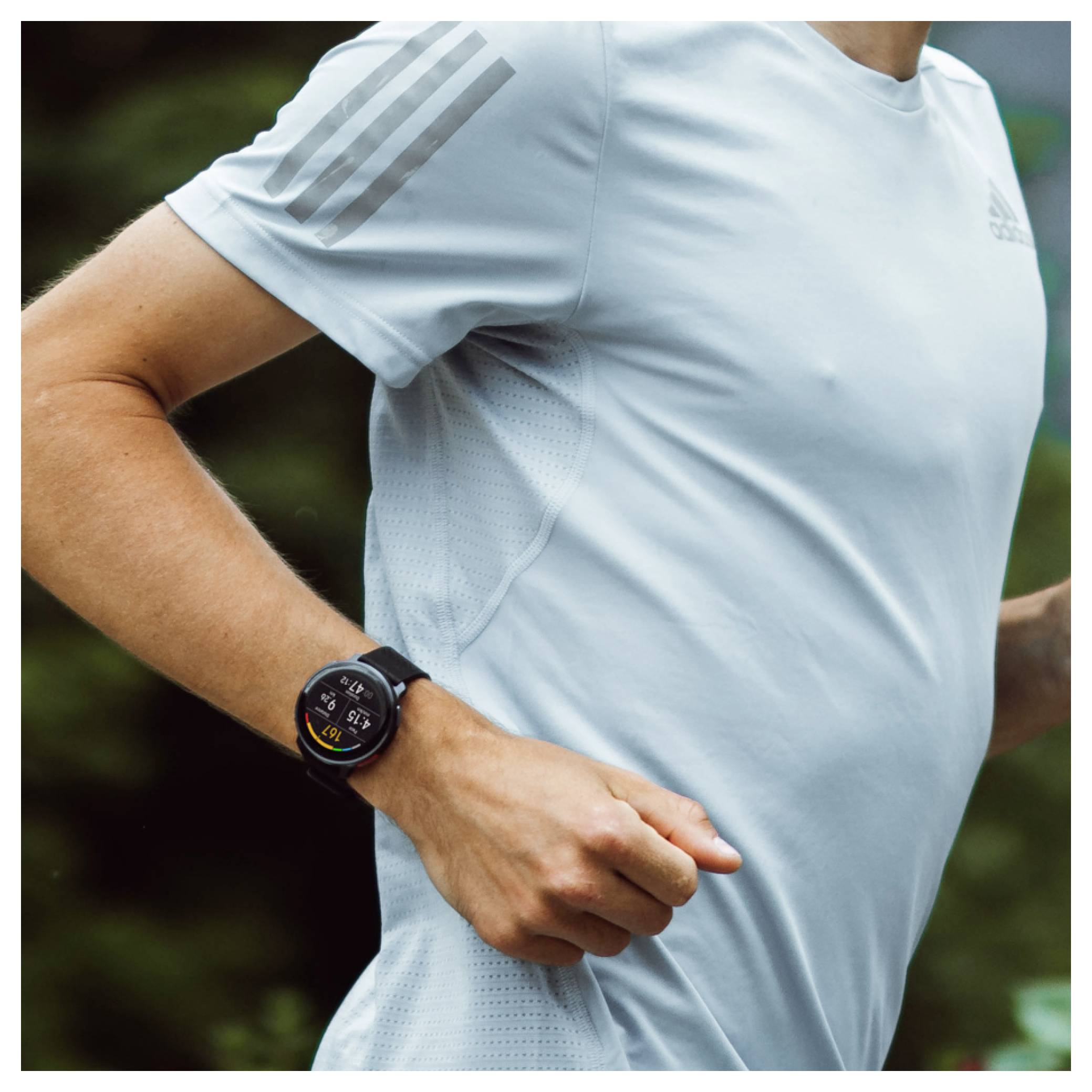 Ein Läufer mit einem hellblauen Shirt und einer Smartwatch joggt im Freien und unterstreicht damit Fitness-Technologie und einen aktiven Lebensstil.