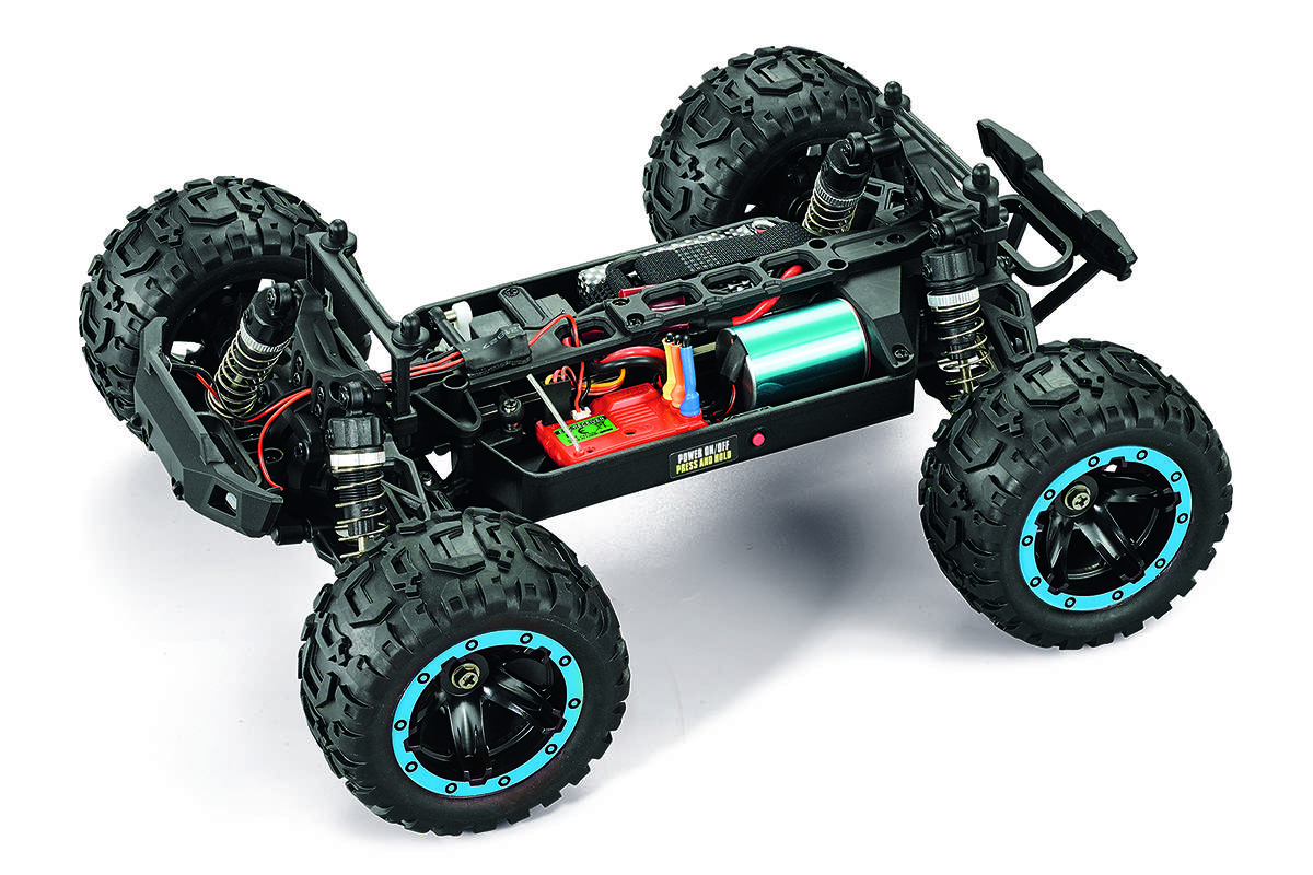 Ein ferngesteuertes Auto mit vier Rädern, freiliegenden Elektronikkomponenten, großen, robusten Reifen und einer hell gefärbten Batterie auf seinem Chassis.
