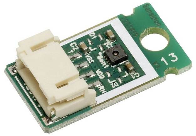 Ein kleines grünes Leiterplatte mit einem weißen Stecker, schwarzem Chip und mehreren elektronischen Komponenten, wahrscheinlich ein Sensormodul für elektronische Geräte.