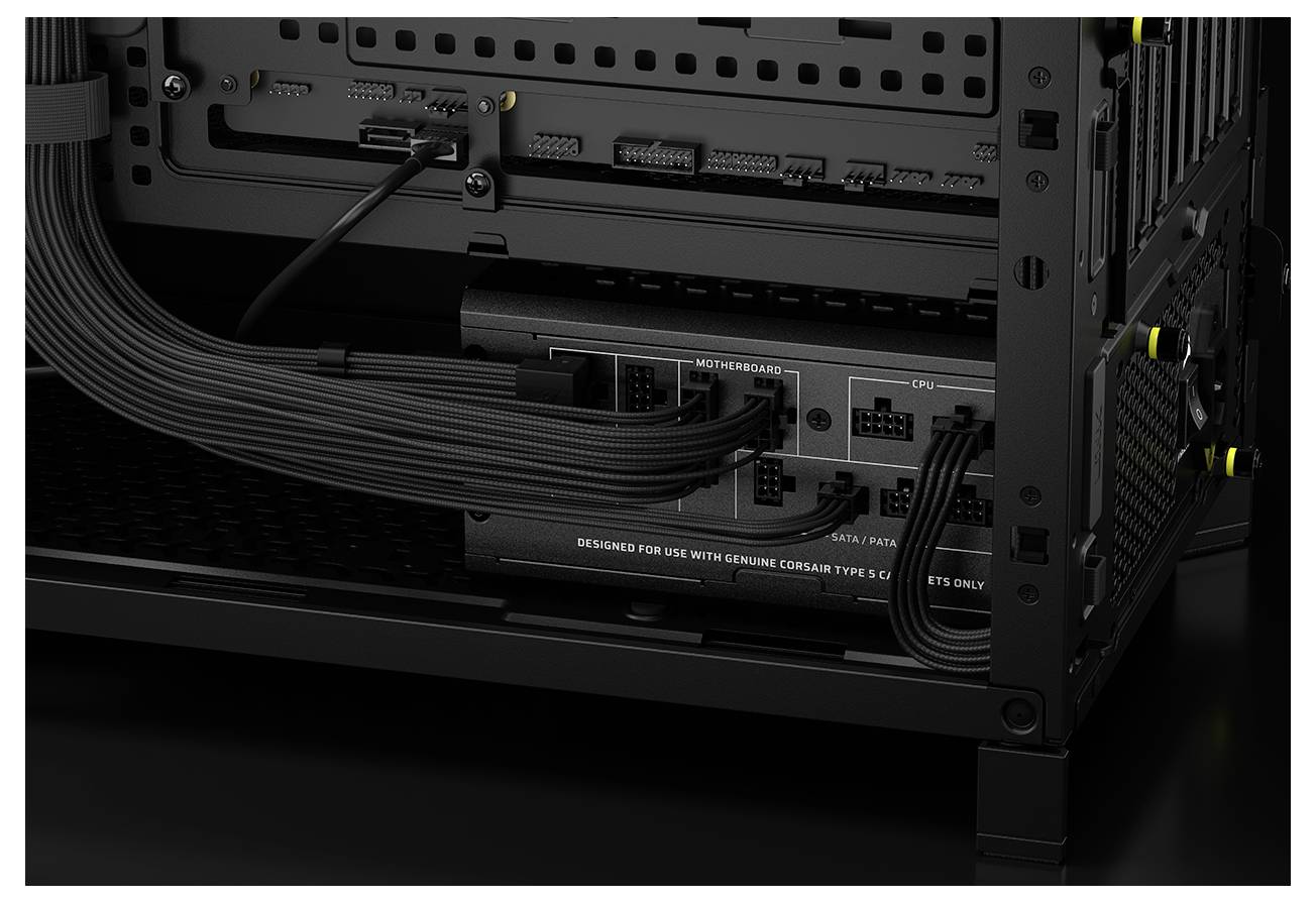 Nahaufnahme des Inneren eines Computergehäuses, die ein Netzteil mit Kabeln zeigt, die an Motherboard und CPU angeschlossen sind und dabei die Kabelführung betonen.