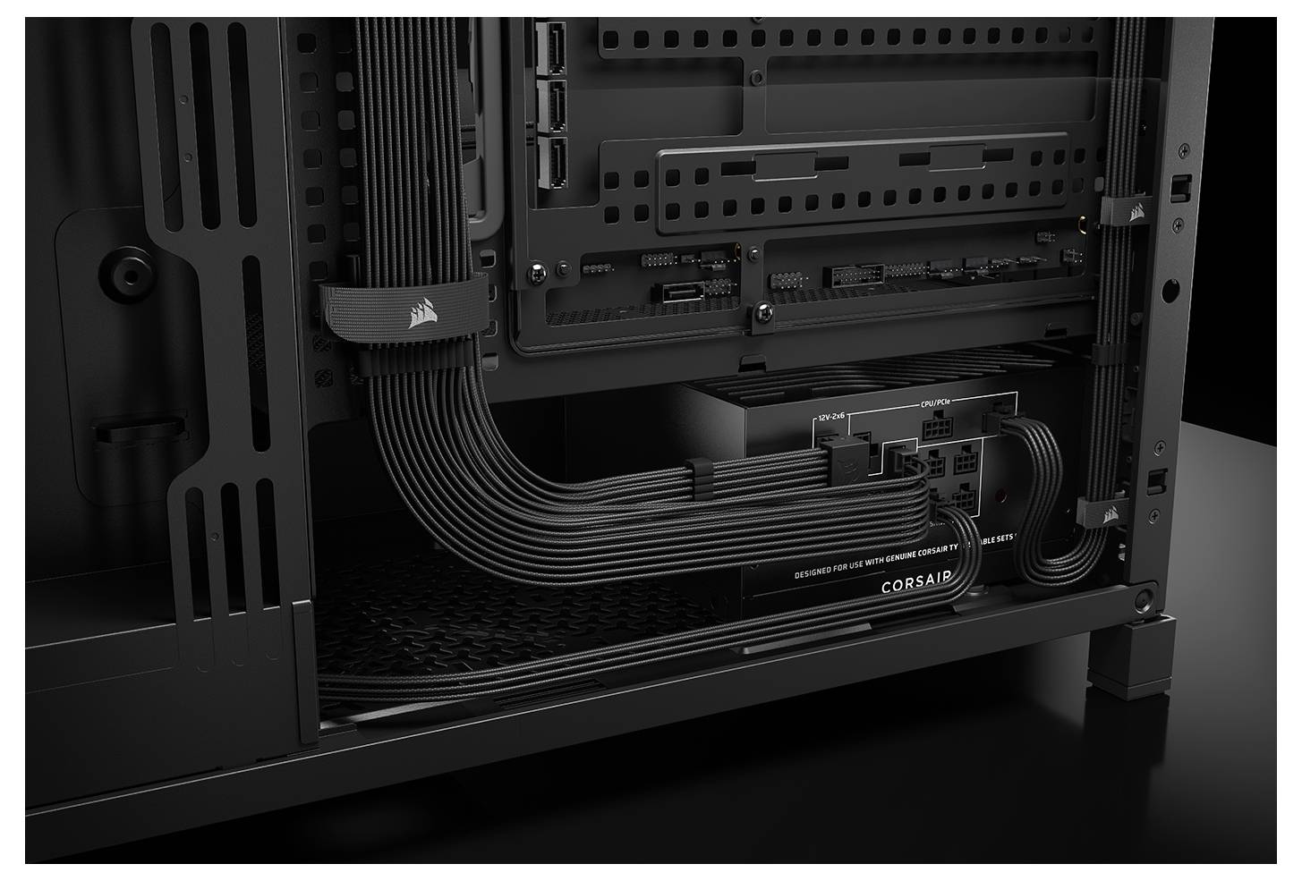 Rückseite eines Computergehäuses mit sauber geführten Kabeln, die mit Netzteil und Mainboard verbunden sind. Corsair-Branding auf Komponenten sichtbar.