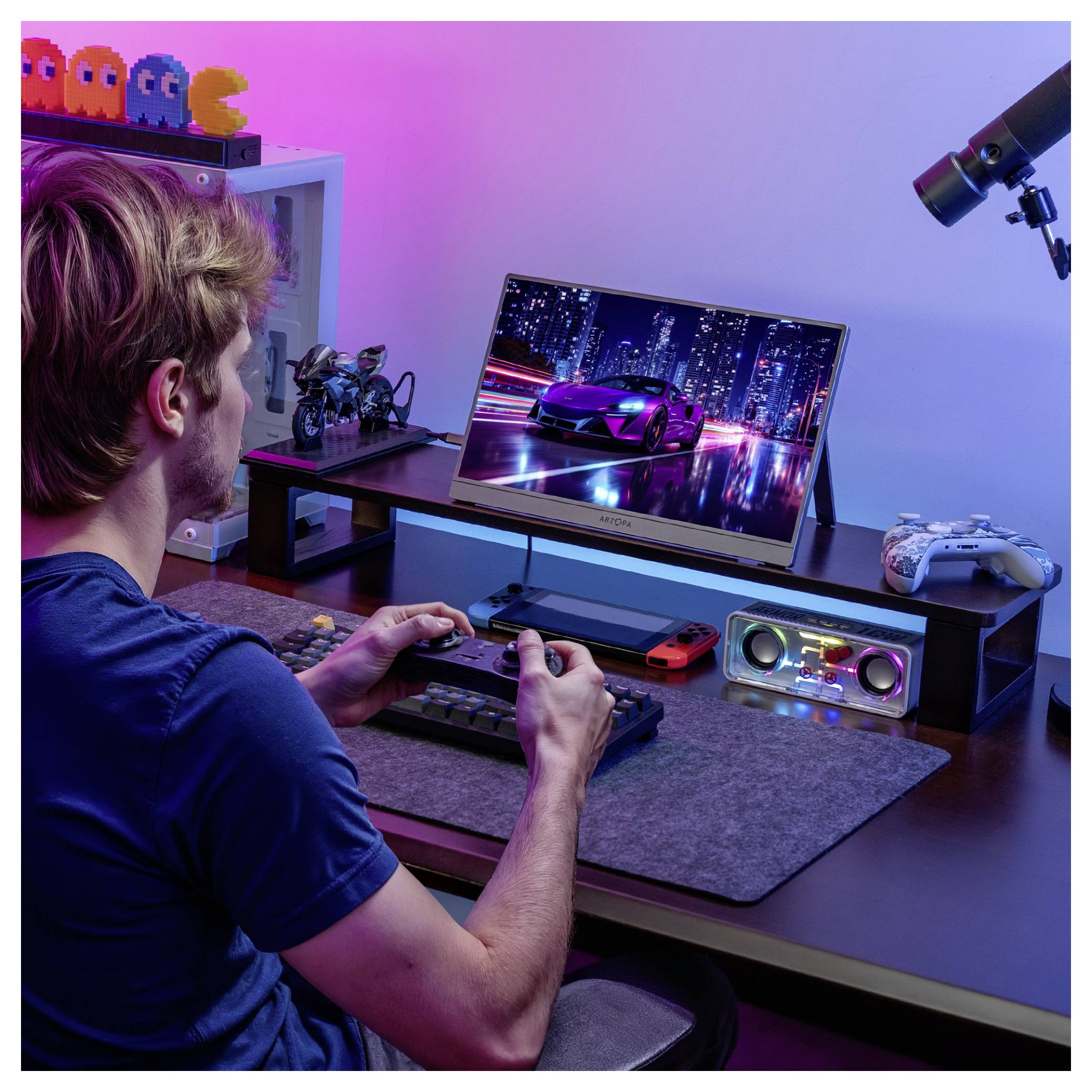 Eine Person spielt ein Rennspiel auf einem Monitor an einem Schreibtisch mit Gaming-Controllern, Lautsprechern und einem Teleskop. Retro-Spielfiguren stehen im Regal.