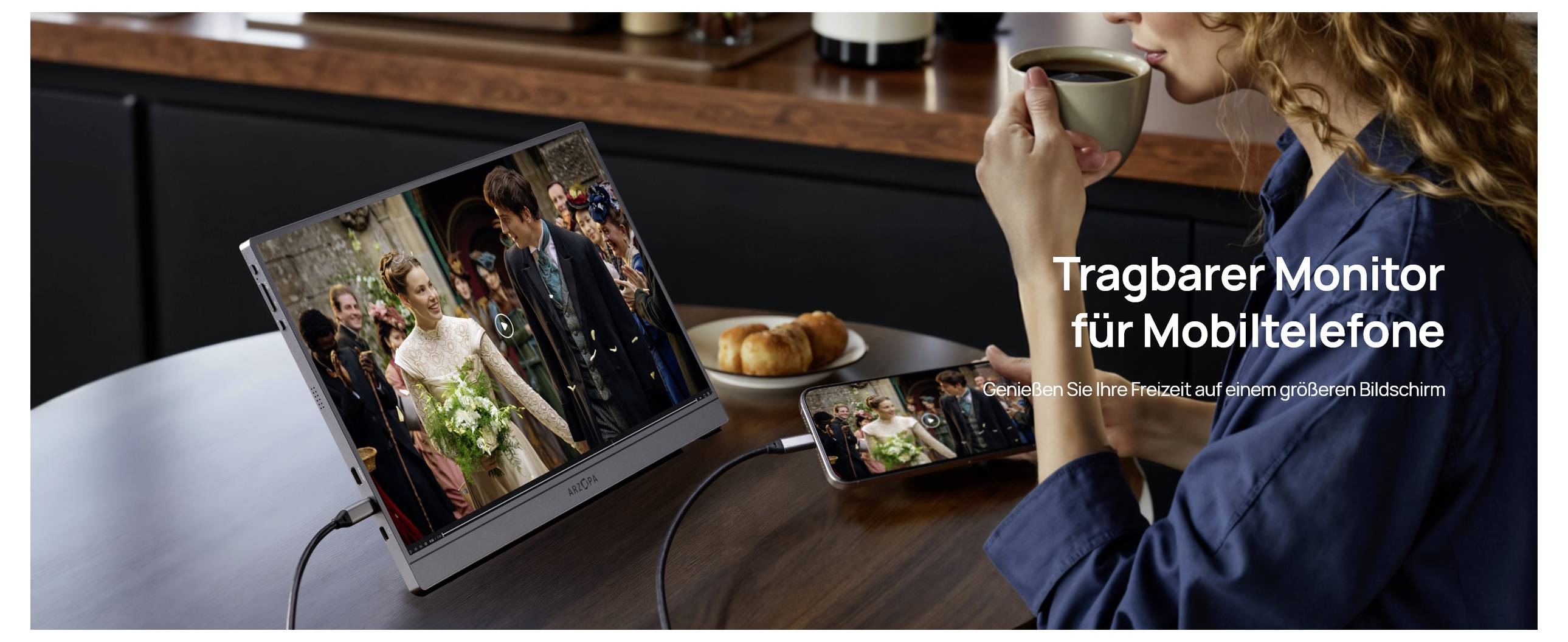 Tragbarer Monitor für Mobiltelefone zeigt eine Hochzeitsszene von einem Handy auf einem größeren tragbaren Bildschirm. Eine Person hält in der Nähe eine Kaffeetasse.