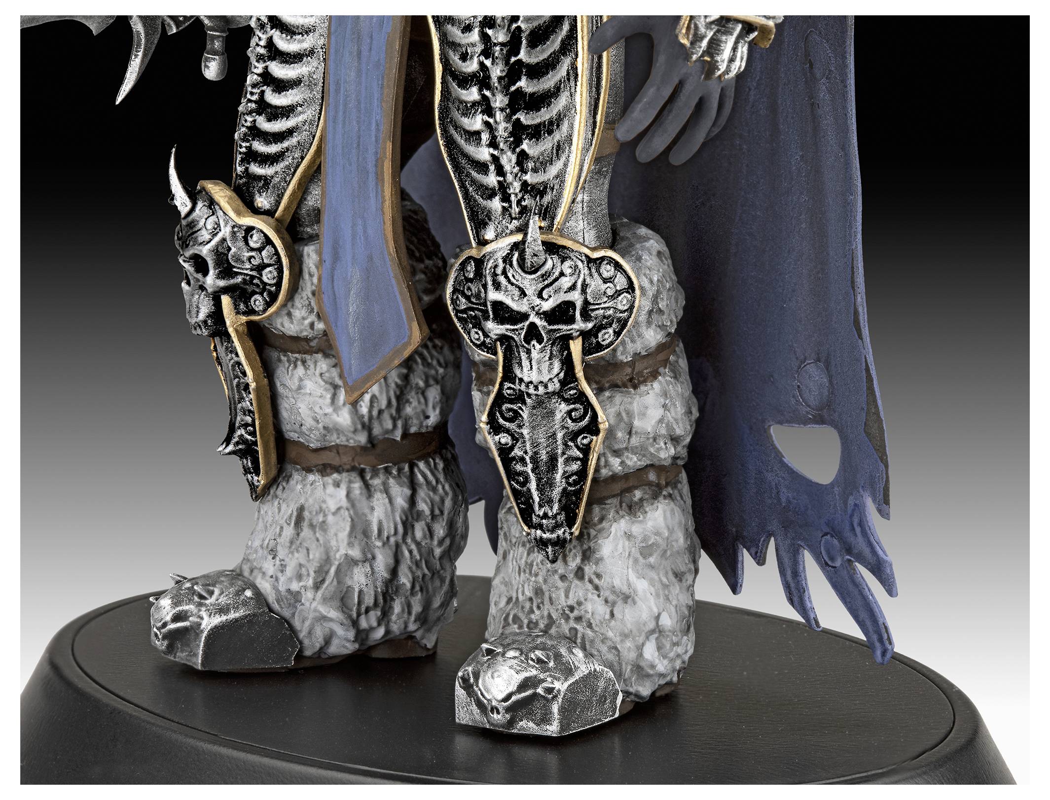 Detaillierte Ansicht der gepanzerten Beine eines Fantasy-Charakters mit kunstvollen Skelettdesigns und pelzbesetzten Stiefeln auf einem Präsentationsständer.