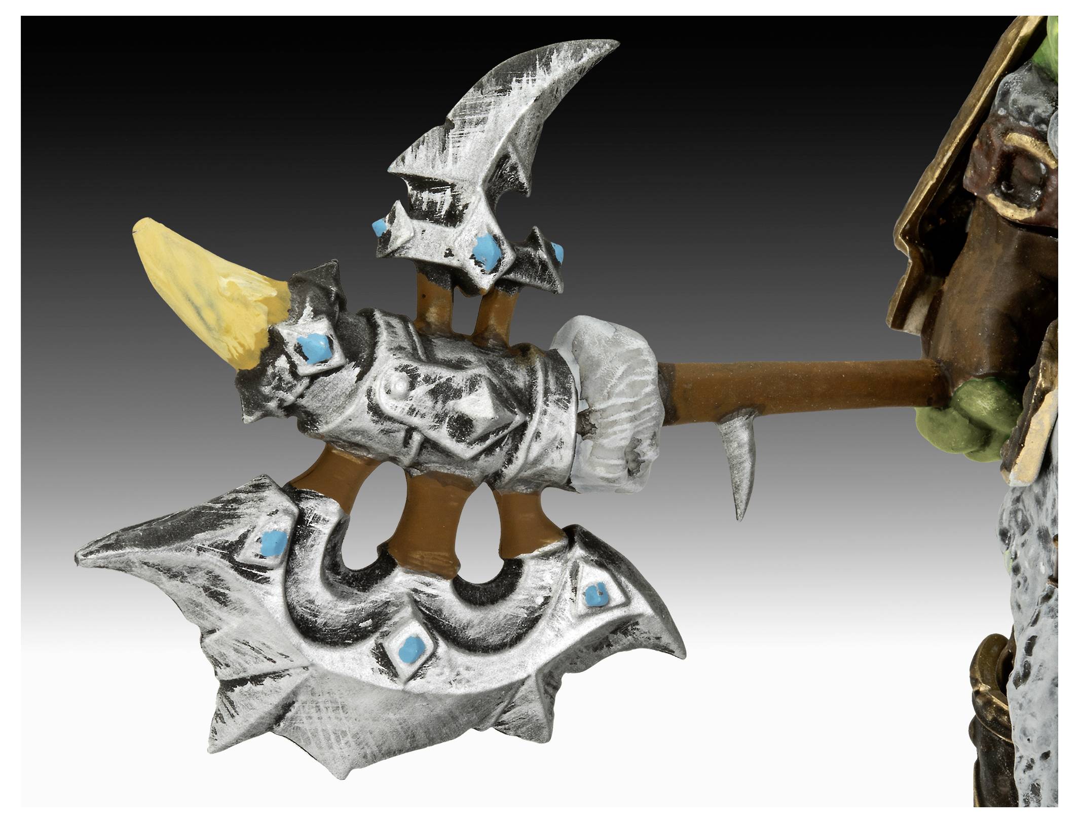 Dekorative Axt mit großen Klingen und blauen Edelsteinen, gehalten von einer Figur, die rechts teilweise sichtbar ist. Die Axt hat einen Holzgriff und ein kompliziertes Design.