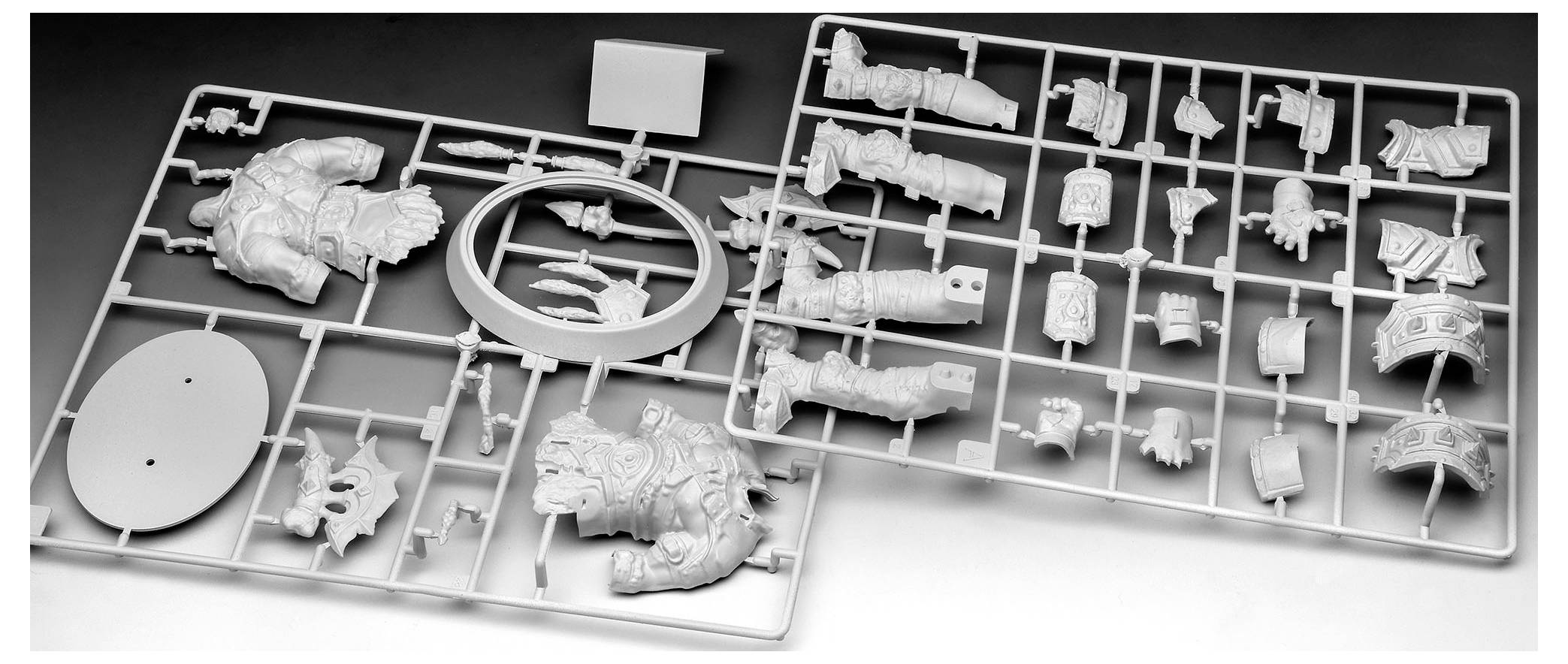 Kunststoff-Modellbausatz-Spritzgussteile mit verschiedenen Komponenten zur Montage, einschließlich Panzer- und Waffenteilen. Die Teile sind auf zwei rechteckigen Rastern angeordnet.