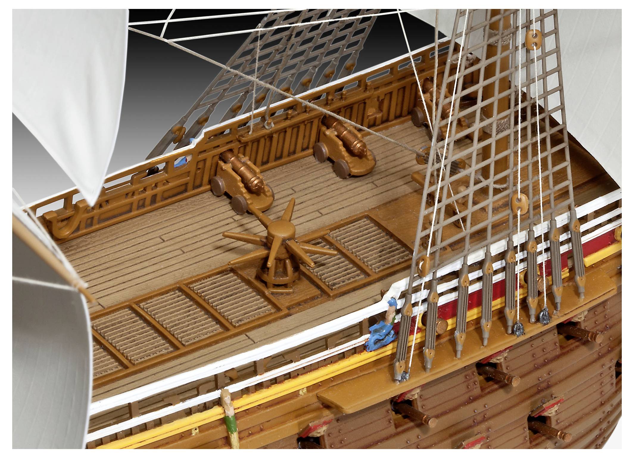 Ein hölzernes Schiffsdeck mit Kanonen, einem Steuerrad, Takelagen und Segeln.