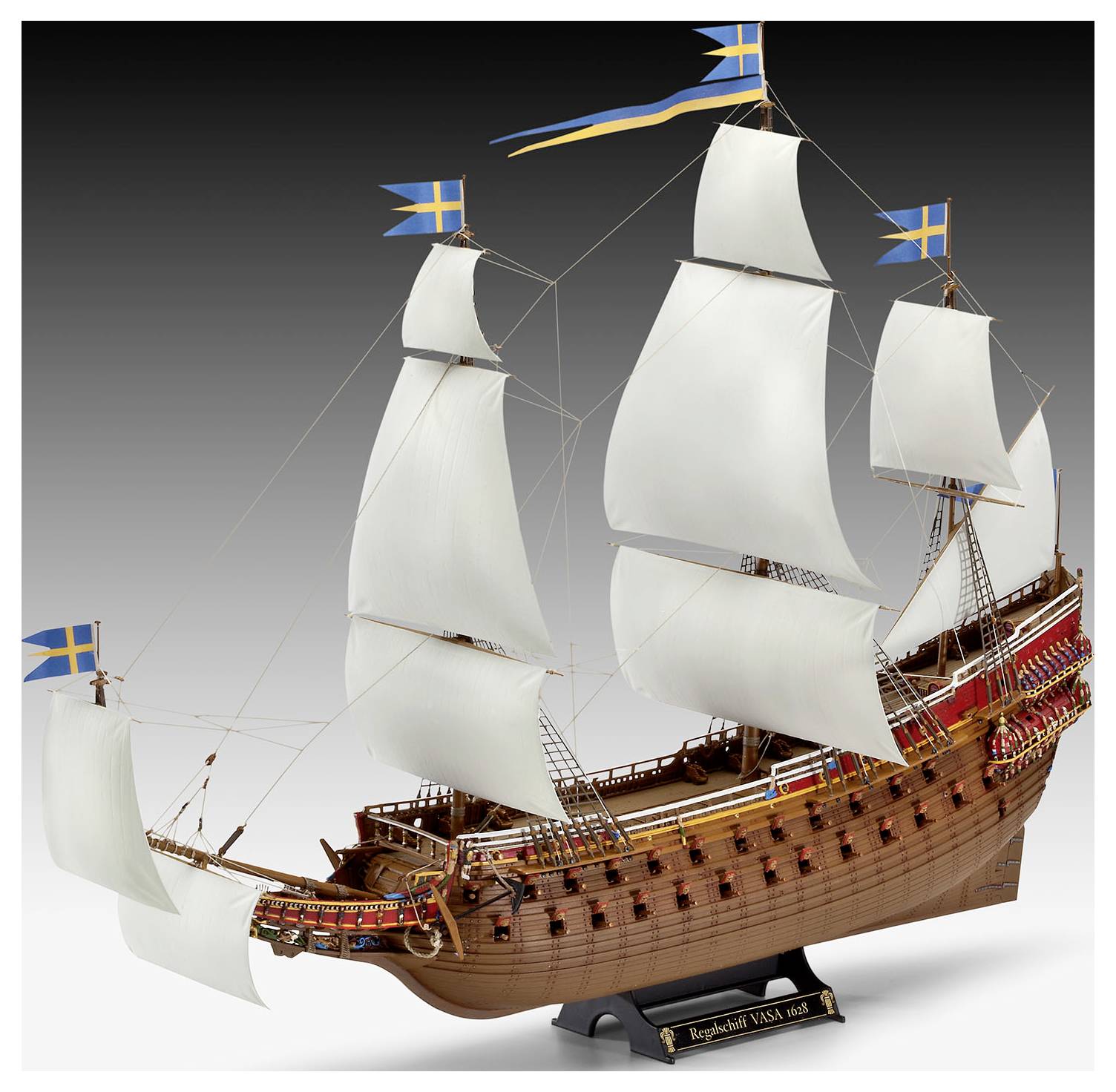 Ein detailliertes Modell des schwedischen Kriegsschiffs Vasa mit weißen Segeln, drei Masten und skandinavischen Flaggen. Das aufwendige Holzdesign des Schiffes ist gut sichtbar.