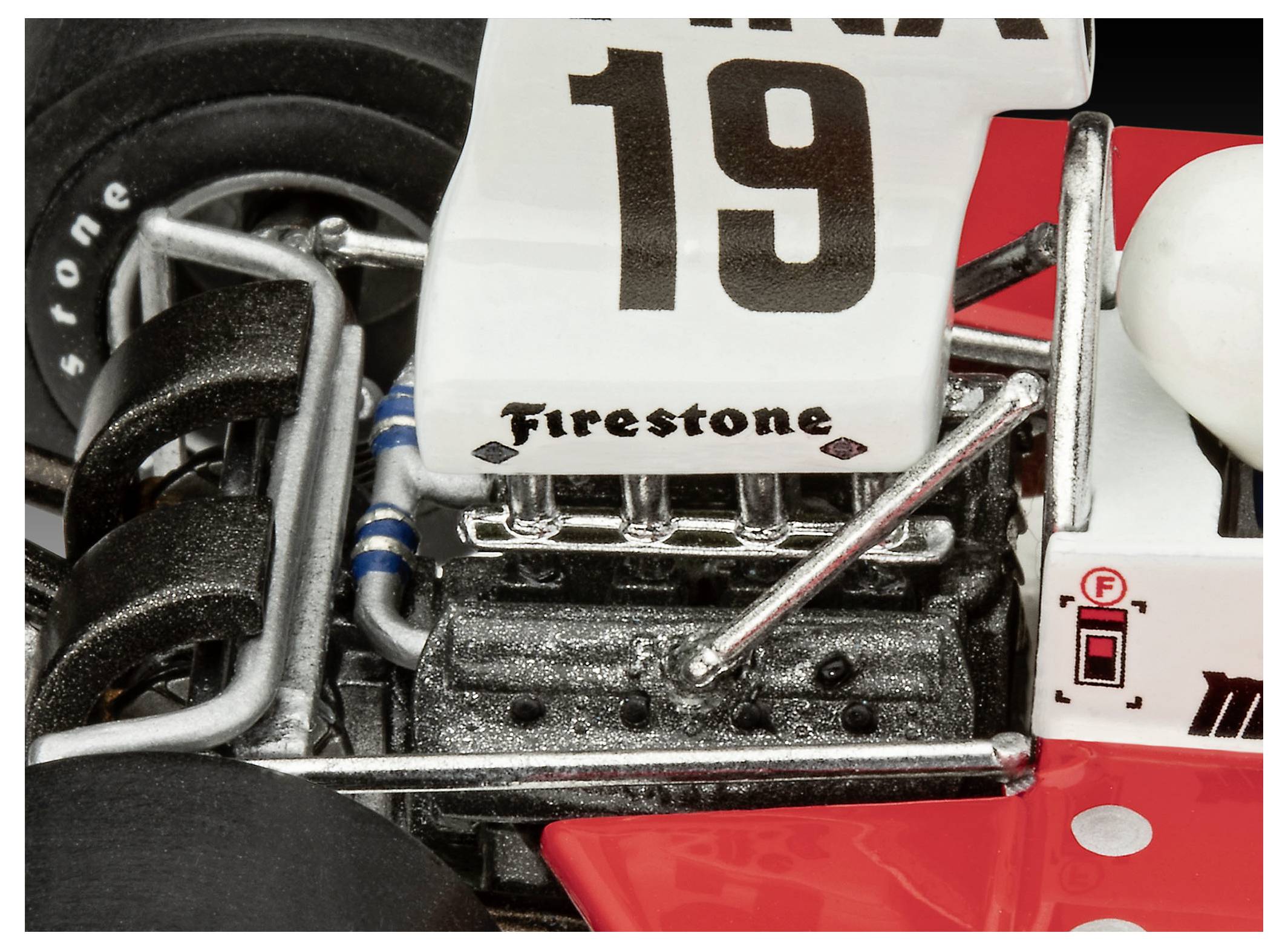 Nahaufnahme eines Vintage-Rennwagens mit einem schwarzen 'Firestone'-Logo in der Nähe des Motors und einer großen '19' auf einem weißen Heck über einem roten Karosseriekörper.