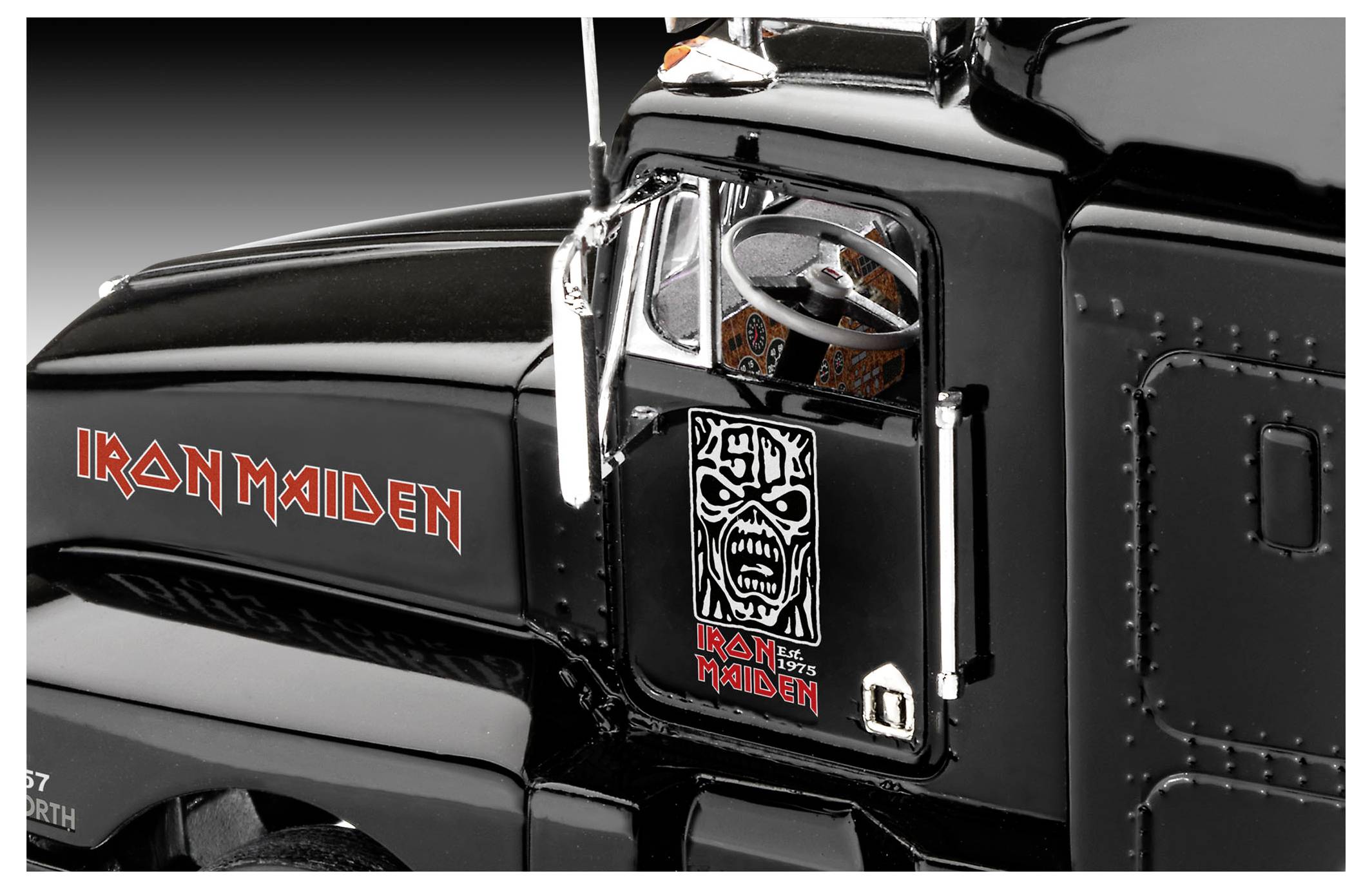 Ein schwarzer LKW-Führerstand mit dem 'Iron Maiden' Logo und Artwork an der Tür, von der Seite betrachtet.