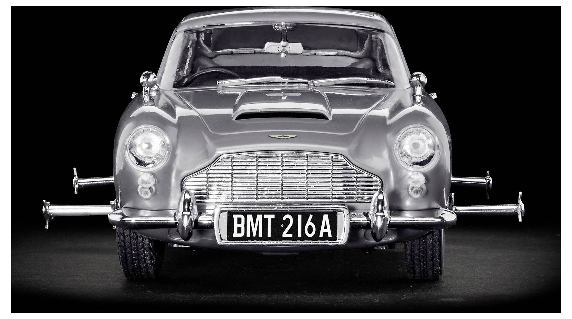 Frontansicht eines klassischen silbernen Sportwagens mit einem Chromgrill, zwei großen Scheinwerfern und einem Nummernschild mit der Aufschrift 