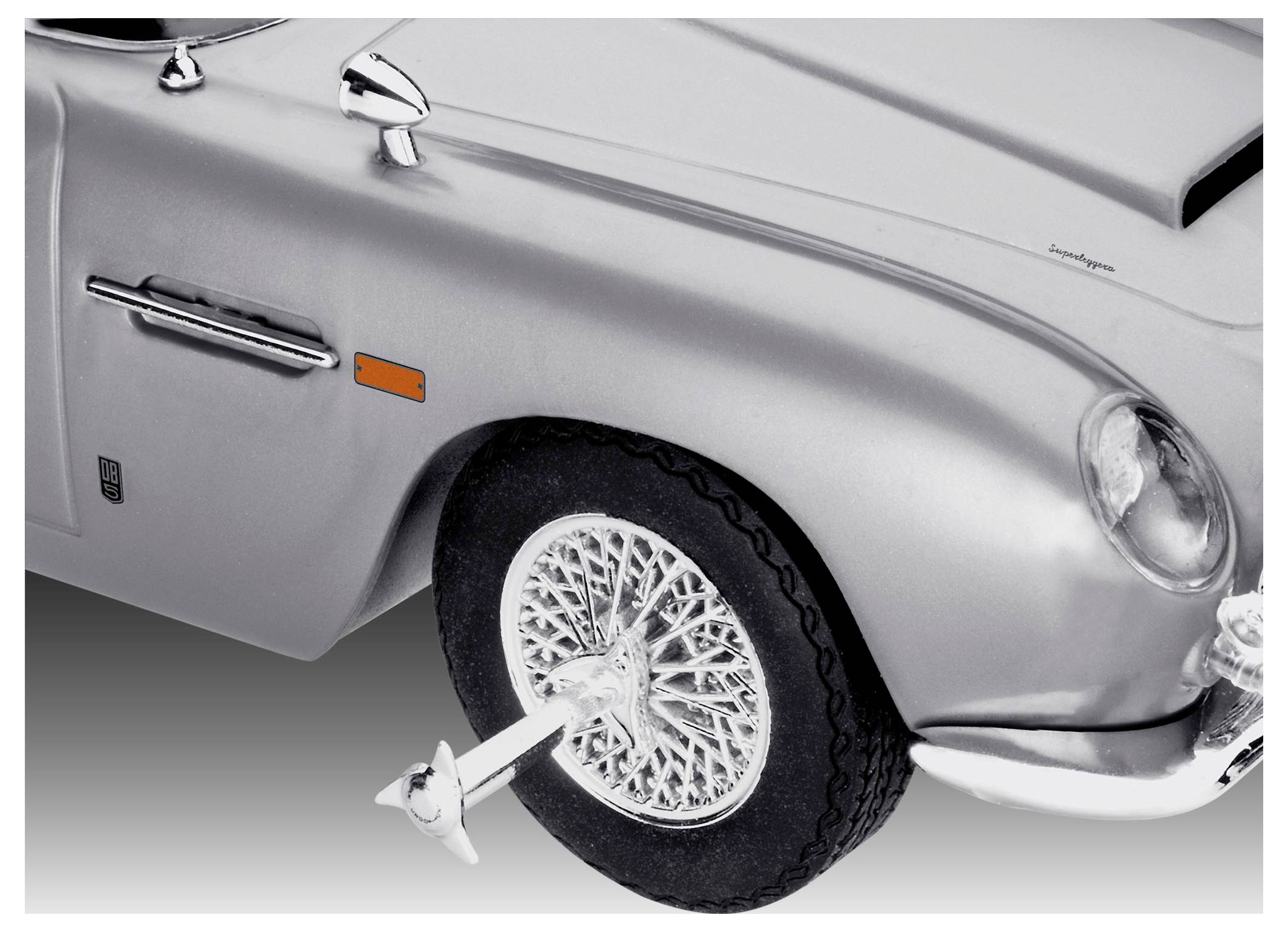 Ein silberner Oldtimer mit einem gezackten Radkappe am Vorderrad, der an ein klassisches Spionagefilm-Fahrzeug erinnert, vor einem Verlaufshintergrund präsentiert.