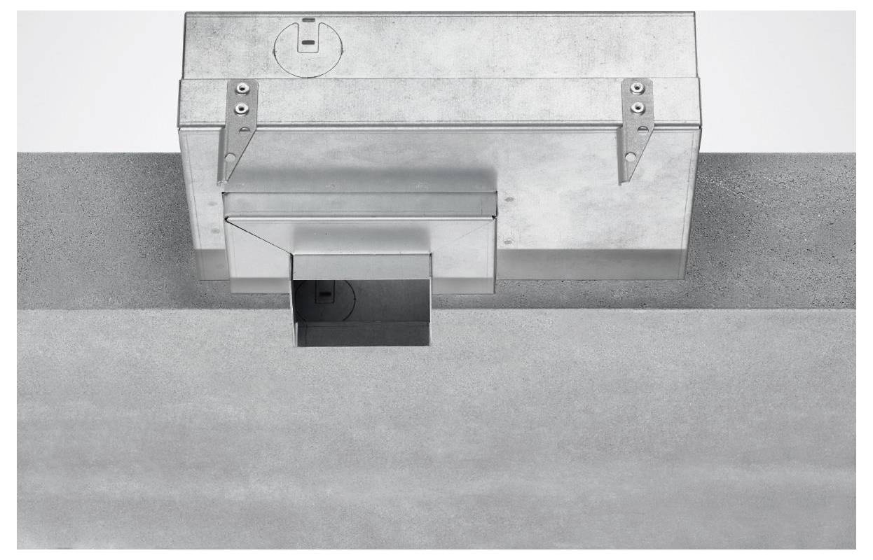 Metallische geschlossene Deckenentlüftung mit rechteckiger Öffnung, an einer massiven Oberfläche angebracht. Deutet auf ein mögliches Luftströmungssystem in einem Gebäude hin.