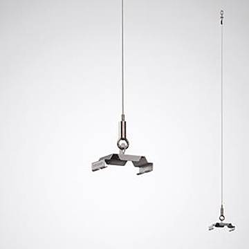 Eine Metallskulptur, die an einem dünnen Draht vor einem hellgrauen Hintergrund aufgehängt ist und aufwendige geometrische Formen im minimalistischen Stil zeigt.