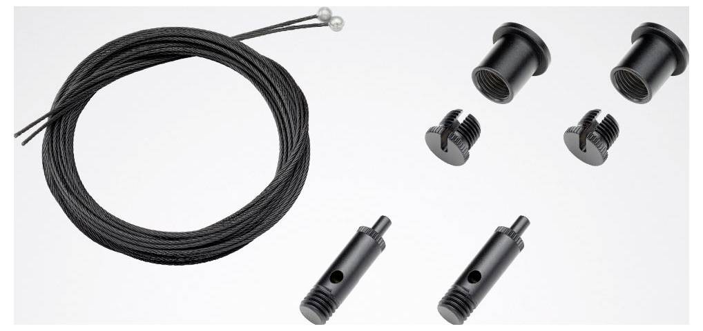 Ein schwarzes Kabel- und Steckerset mit mehreren Gewinde-Steckverbindern und zwei zylindrischen Komponenten mit Löchern, angeordnet auf einer weißen Oberfläche.