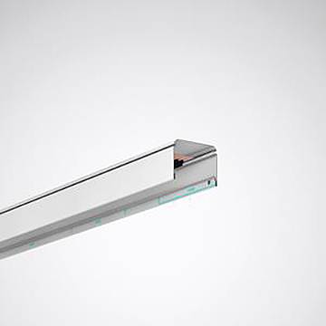 Eine schlanke, moderne LED-Leuchte mit silberner Oberfläche, die kühles weißes Licht ausstrahlt, an einer grauen Wand montiert.