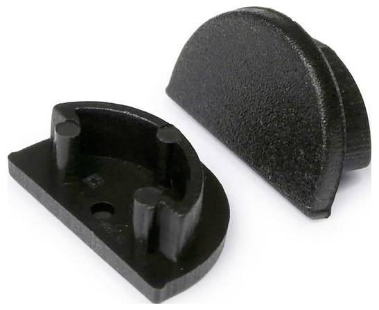 Zwei schwarze halbkreisförmige Kunststoffobjekte; eines aufrecht und eines flach liegend mit vier zylindrischen Stiften. Verwendet als schützende Kabelklemmen.