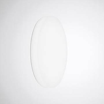 Eine ovale, weiße, minimalistische Wandleuchte vor einem einfachen weißen Hintergrund.